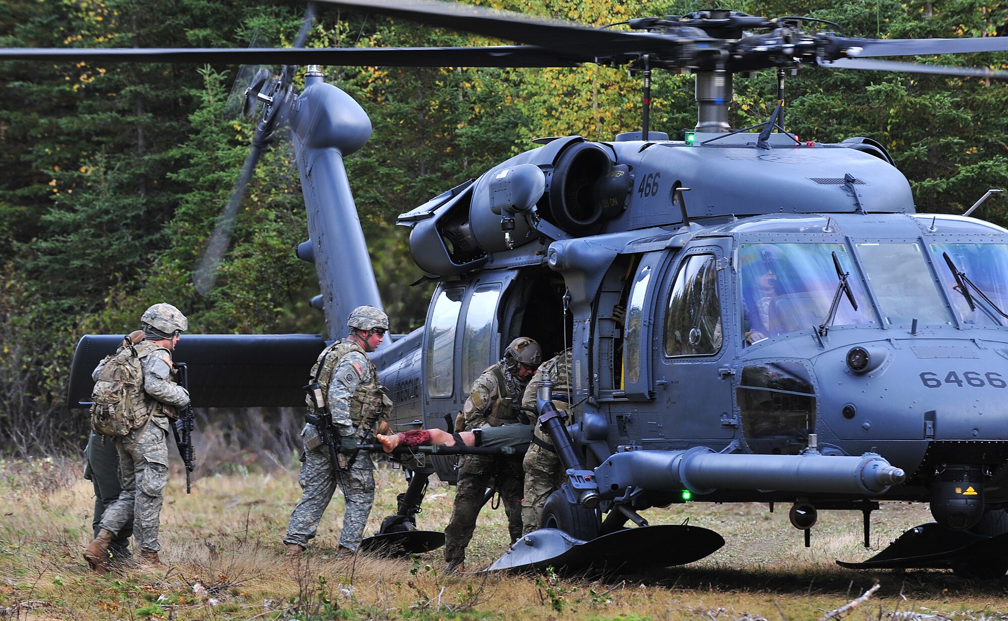 Pararescuemen from the 212th Rescue Squadron and members of Baker Company, 3rd Battalion (Airborne),, 509th Infantry Regiment, load a casualty into an HH-60G Pavehawk helicopter during training on Joint Base Elmendorf-Richardson September 21, 2011.  The training focused on quick-care-under-fire and also gave training to Baker Company on how to react when pararescuemen arrive.  (U.S. Air Force photo/Staff Sgt. Zachary Wolf) 