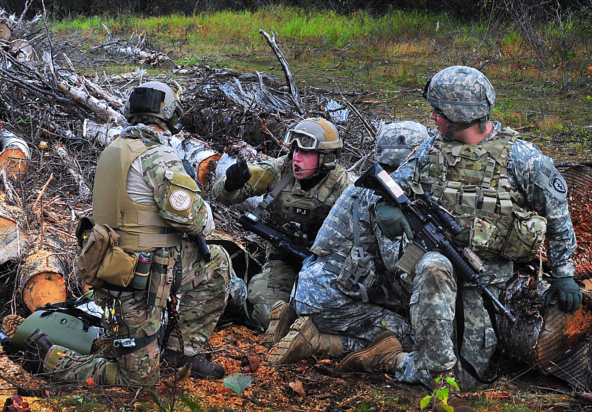 Staff Sgt. BIll Cenna, 212th Rescue Squadron pararescueman, briefs Staff Sgt. Jason Ruiz, 212th Rescue Squadron pararescueman, on his patient's status during training at Joint Base Elmendorf-Richardson on September 21, 2011.  The training focused on quick-care-under-fire and also gave training to Baker Company, 3rd Battalion (Airborne), 509th Infantry Regiment, on how to react when pararescuemen arrive.  (U.S. Air Force photo/Staff Sgt. Zachary Wolf) 