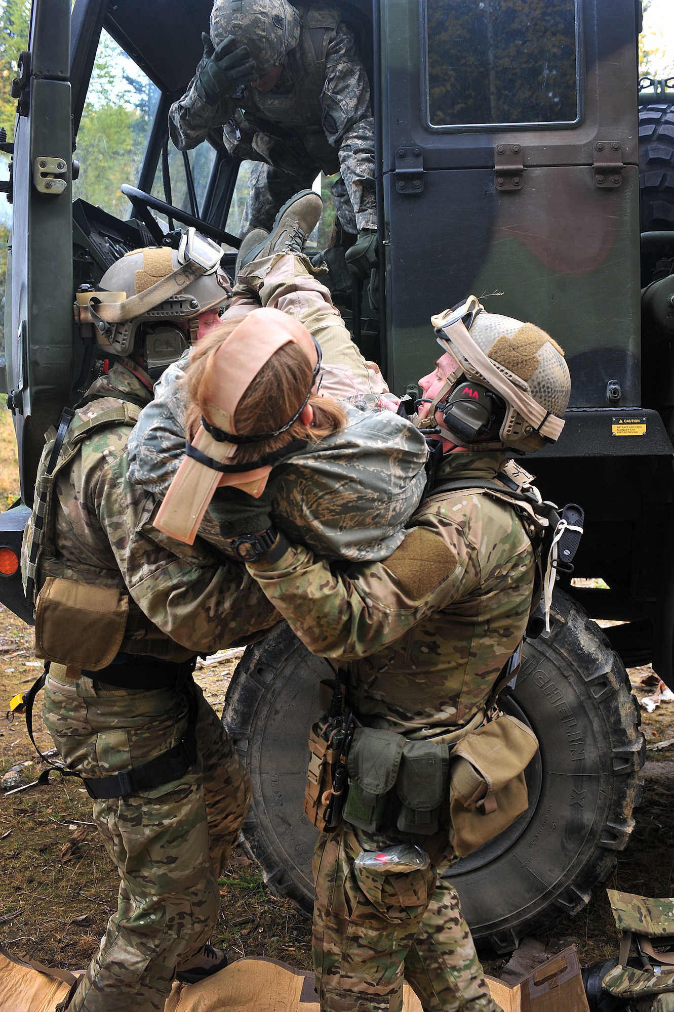Staff Sgt. BIll Cenna (left) and Tech. Sgt. Jeremy Maddamma (right), 212th Rescue Squadron pararescuemen, remove a patient from a truck during training at Joint Base Elmendorf-Richardson on September 21, 2011.  The training focused on quick-care-under-fire and also trained Baker Company, 3rd Battalion (Airborne), 509th Infantry Regiment, on how to react when pararescuemen arrive.  (U.S. Air Force photo/Staff Sgt. Zachary Wolf)