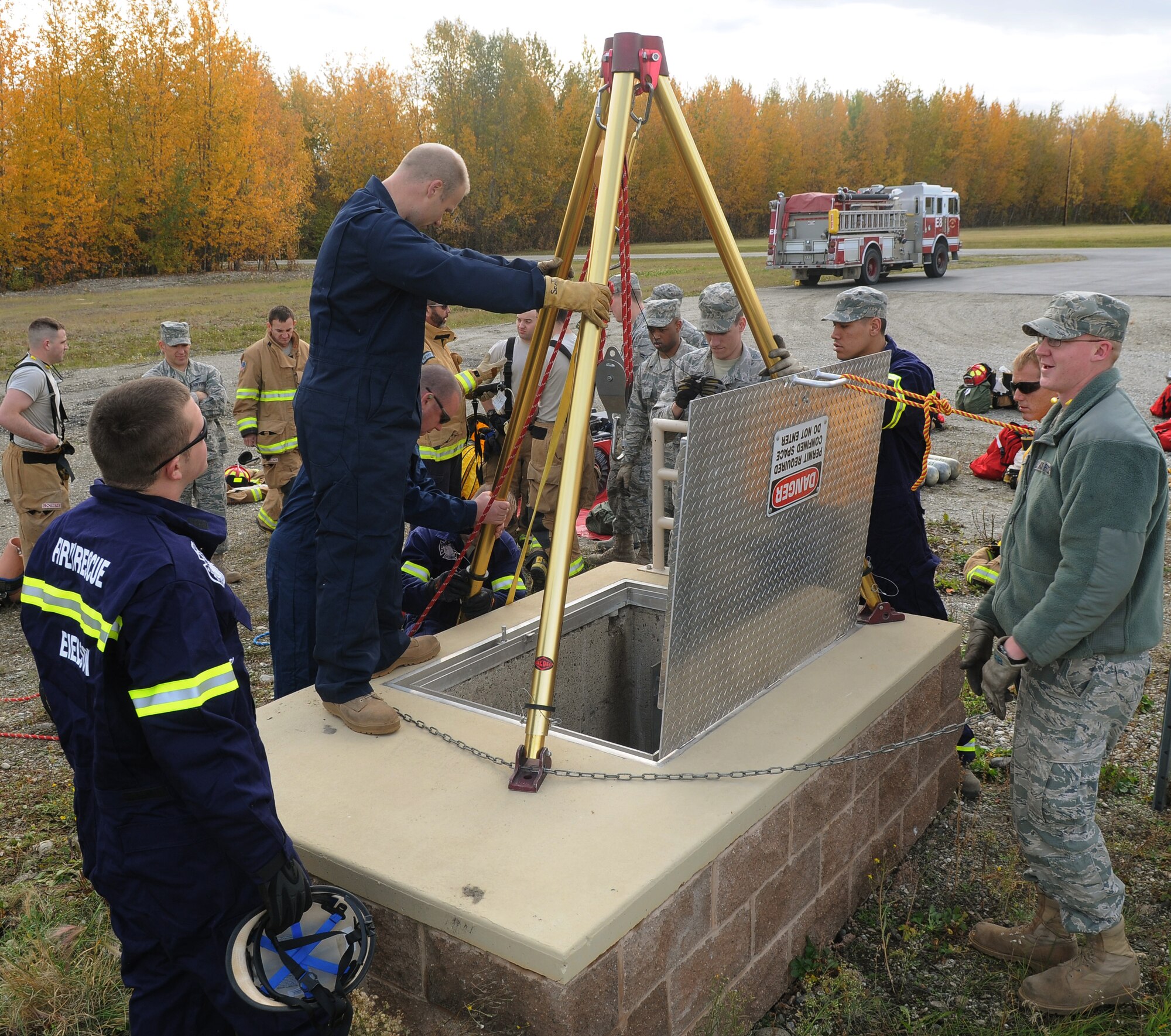 Airmen gather around to watch fellow firefighters perform a confined space rescue scenario Sept. 14, 2011, Eielson Air Base, Alaska.  This training, which emphasizes awareness and problem solving at the technician level, is advanced but also covers basic training as well. (U.S. Air Force photo/Senior Airman Janine Thibault)