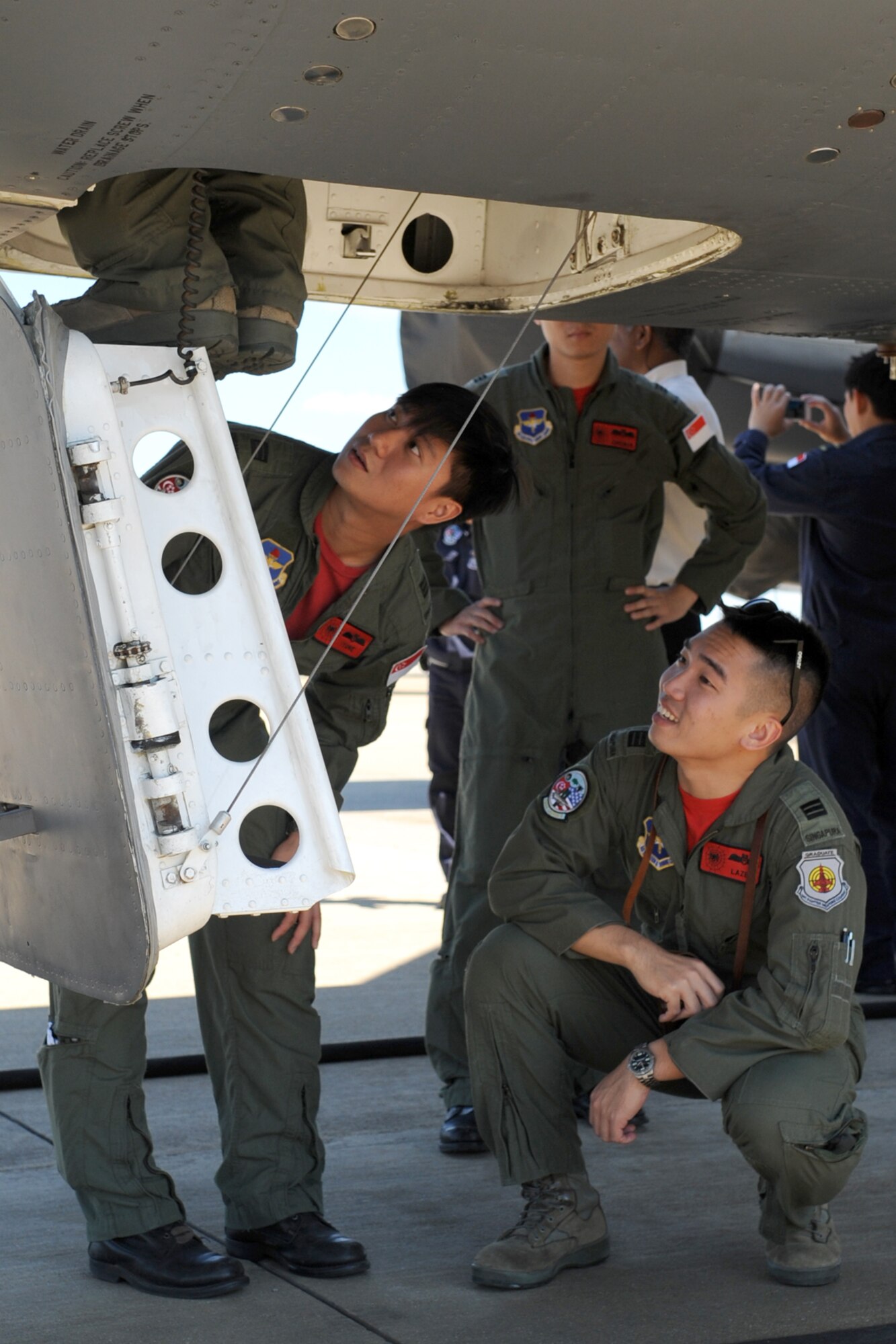 Republic of Singapore pilots eagerly wait for their turn in the cockpit of a B-52 Stratofortress during a tour at Barksdale Air Force Base, La., Sept. 23, 2011. The pilots are assigned to the 425th Fighter Squadron, Luke Air Force Base, Ariz., which provides continued advanced weapons and tactics training for the F-16 Fighting Falcon. (U.S. Air Force photo by Master Sgt. Greg Steele/Released)