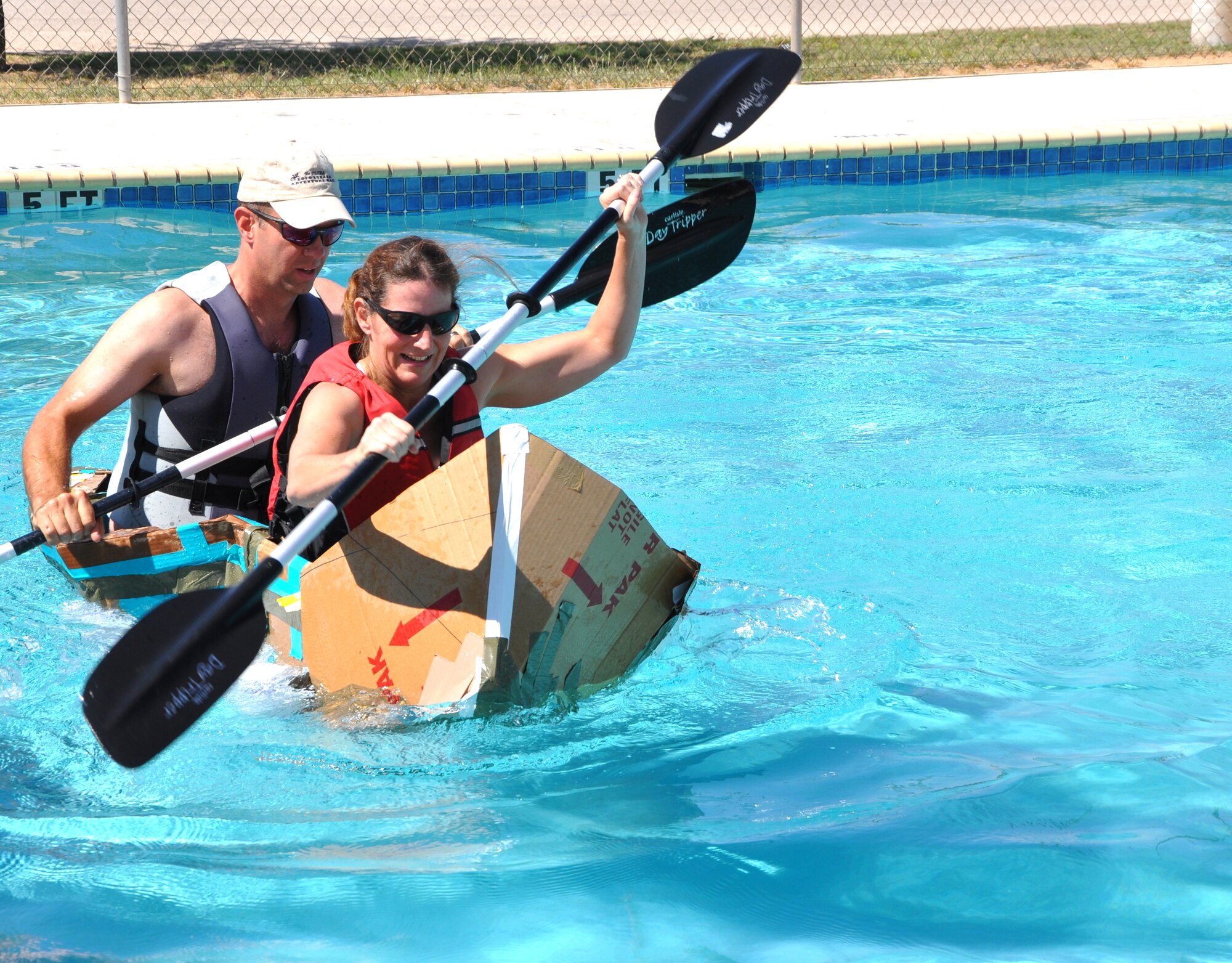 SAN ANGELO, Texas -- Lt. Col. Jeffrey McBride, 17th Mission Support Group deputy commander, and his wife, Christina, speed down the Recreation Camp pool with ease in their makeshift boat of cardboard, duct tape and milk jugs during the Build a Boat contest Sept. 24.  Their team, Puppies and Ponies, won The Fastest Boat category against five other teams during the event. (U.S. Air Force photo/Connie Hempel)