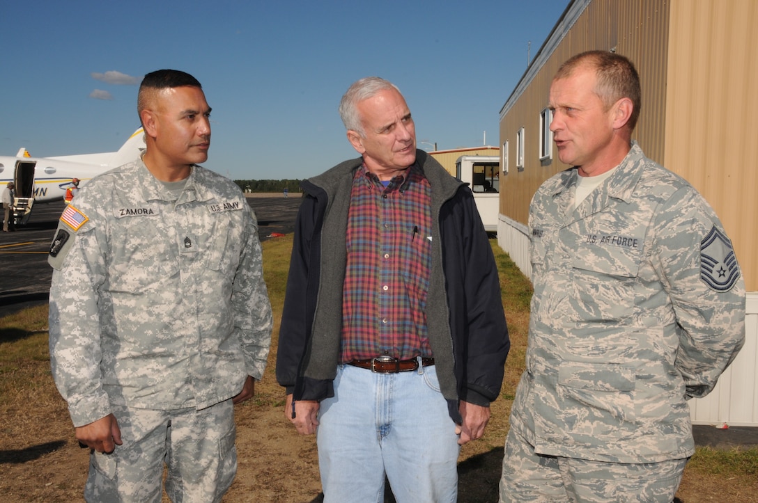 Minn. Gov. Mark Dayton meets with 148th Fighter Wing member Senior Master Sgt. Ted Windus Jr. and Minnesota Army National Guard member Sgt. 1st Class Miguel Zamora, in Ely, Minn. Sept. 16, 2011.  Senior Master Sgt. Windus and Sergeant 1st Class Zamora explained how the Air and Army National Guard worked hand-in-hand to battle the fires in the Ely, Minn. area using Blackhawk helicopters and the refueling trucks necessary to keep them airborne and full of fuel.  (U.S. Air Force photo by Master Sgt. Ralph J. Kapustka.)