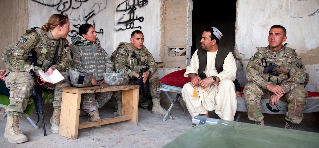 U.S. Army soldiers and an interpreter sit with a Spin Boldak resident in Afghanistan's Kandahar province, Sept. 15, 2011.