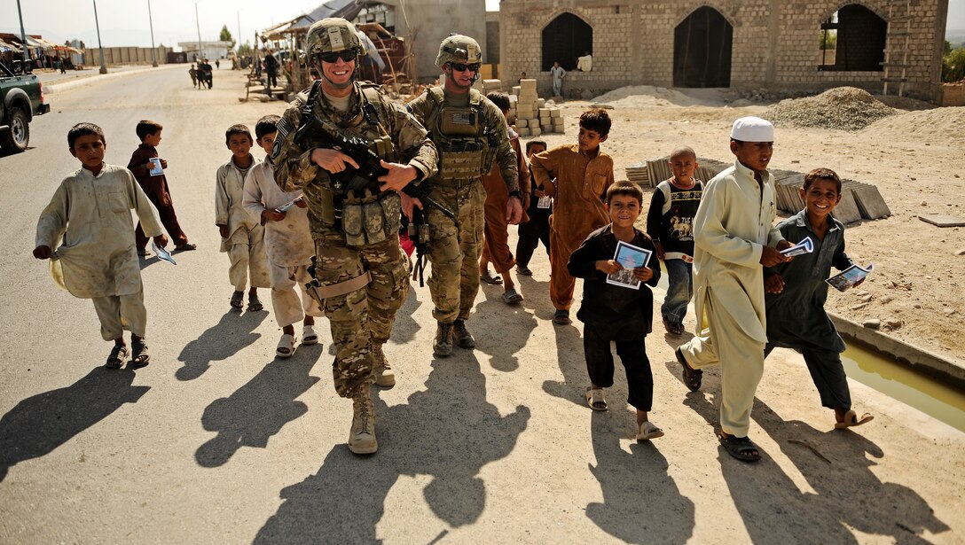 U.S. Army Capt. Brandon Delatorre and Staff Sgt. Jason Roberts walk and talk with children in the Mehtar Lam district in Afghanistan's Laghman province, Sept. 26, 2011. 