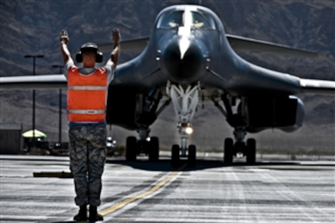 U.S. Air Force Senior Airman Jonathon Hartman directs the flight crew of a B-1B Lancer aircraft during Green Flag-West 11-10 at Nellis Air Force Base, Nev., on Sept. 20, 2011. Green Flag-West is a joint U.S. Air Force-U.S. Army unscripted battle exercise designed to train participants for complex air defense scenarios while supporting high-intensity ground operations.  Hartman is a 7th Aircraft Maintenance Squadron crew chief.  