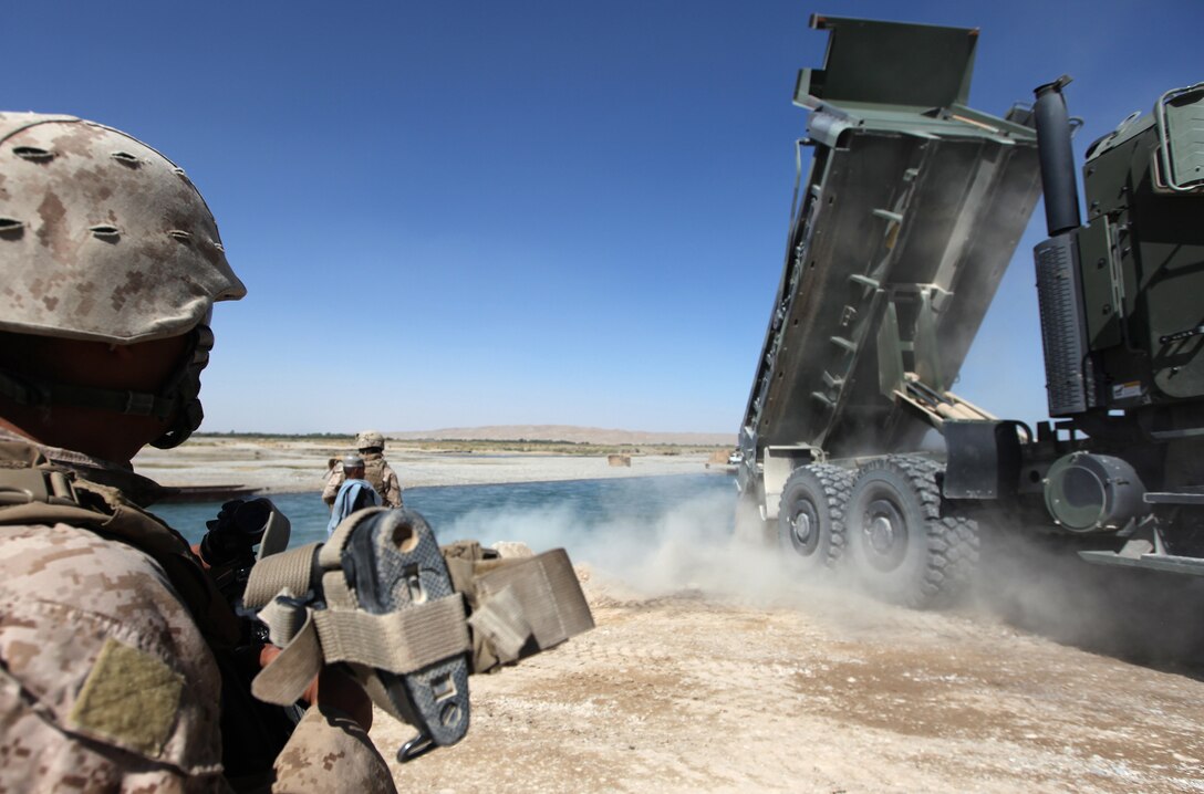 Cpl. Carlos Sanchez, a heavy equipment mechanic with Support Company, 7th Engineer Support Battalion, provides security as Marines continue work on a causeway into Helmand River near Forward Operating Base Sabit Qadam, Afghanistan, Sept. 27. In addition to personnel with 7th ESB, Combat Logistics Battalion 6, Naval Mobile Construction Battalion 4 Seabees and Marine Wing Support Squadron 272 all played an instrumental role in completing the causeway. (U.S. Marine Corps photo by Sgt. Justin J. Shemansk)