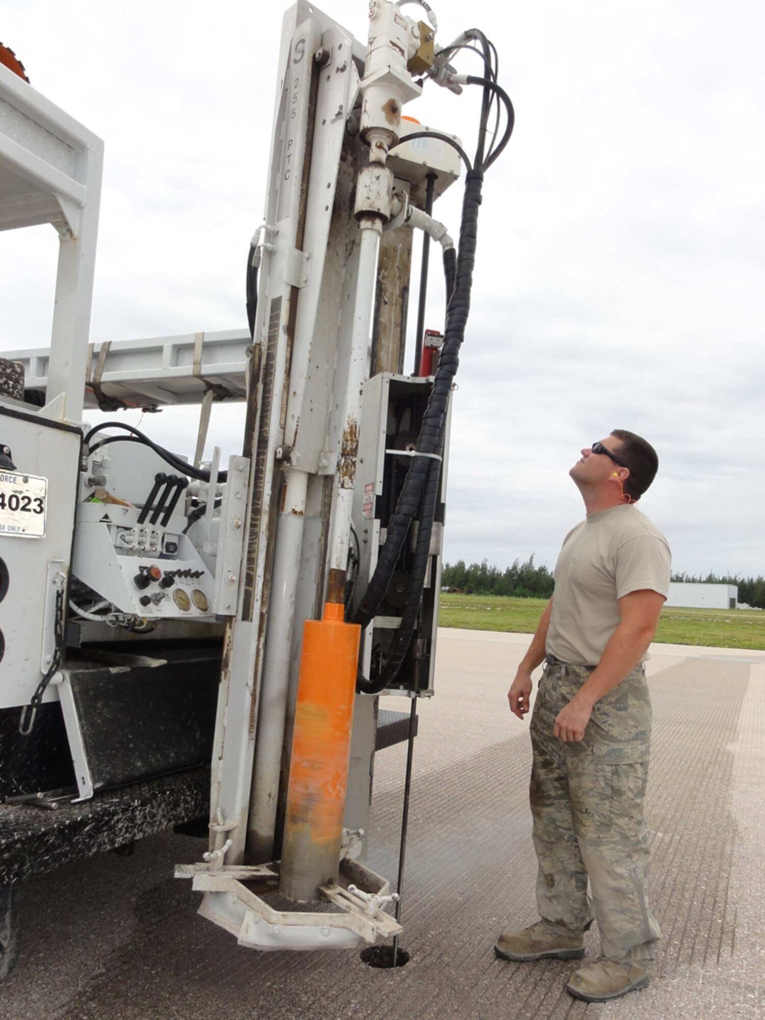 Tech. Sgt. Jeremy Morgan, AFCE SA Airfield Pavement Evaluation technician, looks at the automated dynamic core penetrometer, a specialized instrument that measures the strength of the soil under the pavement. (U.S. Air Force photo/Capt Amy Hansen)