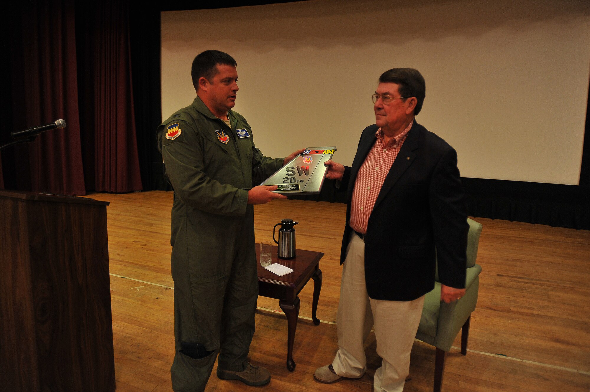 Col. Don Godier, 20th Fighter Wing vice commander, presents Jack Van Loan, a former prisoner of war, with a 20th Fighter Wing plaque in appreciation of his service at the Shaw Air Force Base Theater, Sept. 27, 2011. Van Loan was held in captivity for approximately six years in North Vietnam after he was shot down on May 20, 1967. Van Loan was held until his release on March 4, 1973. Van Loan was the guest speaker, and he spoke to Shaw members for Wingman Safety Day and highlighted the importance of being a good wingman. The former prisoner of war said his wife, mom, dad and three children helped him get through the hard times in captivity. (U.S. Air Force photo by Senior Airman Kenny Holston/Released)


