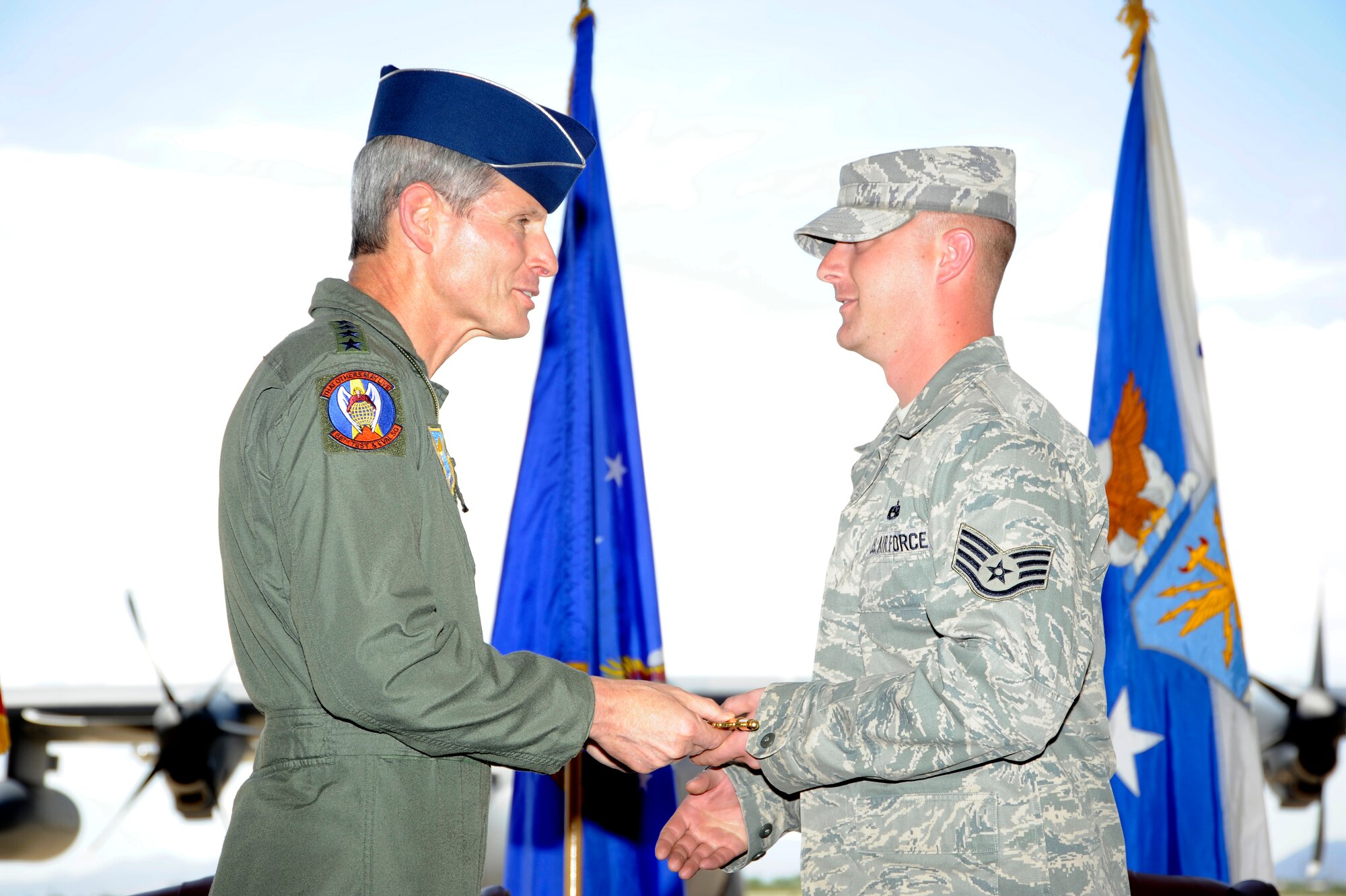 DAVIS-MONTHAN AIR FORCE BASE, Ariz. - Air Force Chief of Staff Gen. Norton Schwartz hands a ceremonial key to Staff Sgt. Christopher Meyer, 923rd Aircraft Maintenance Squadron, during the HC-130J Combat King II arrival ceremony at Davis-Monthan Air Force Base, Ariz., on Sept. 24, 2011. The 923rd AMXS will maintain the newly arrived HC-130J, and Meyer will be the dedicated crew chief to the aircraft. The new J-model aircraft will replace the Air Force’s current HC-130s, which have been flown for more than 40 years.  (U.S. Air Force photo/Tech. Sgt. Christopher A. Campbell)