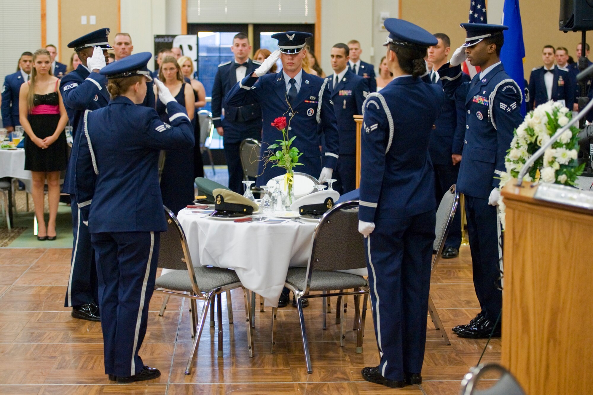Members of Malmstrom's Honor Guard salute hats representing prisoners of war and persons missing in action within each branch of military service as part of the opening ceremonies for the Air Force Ball Sept. 17.  (U.S. Air Force photo/Beau Wade)