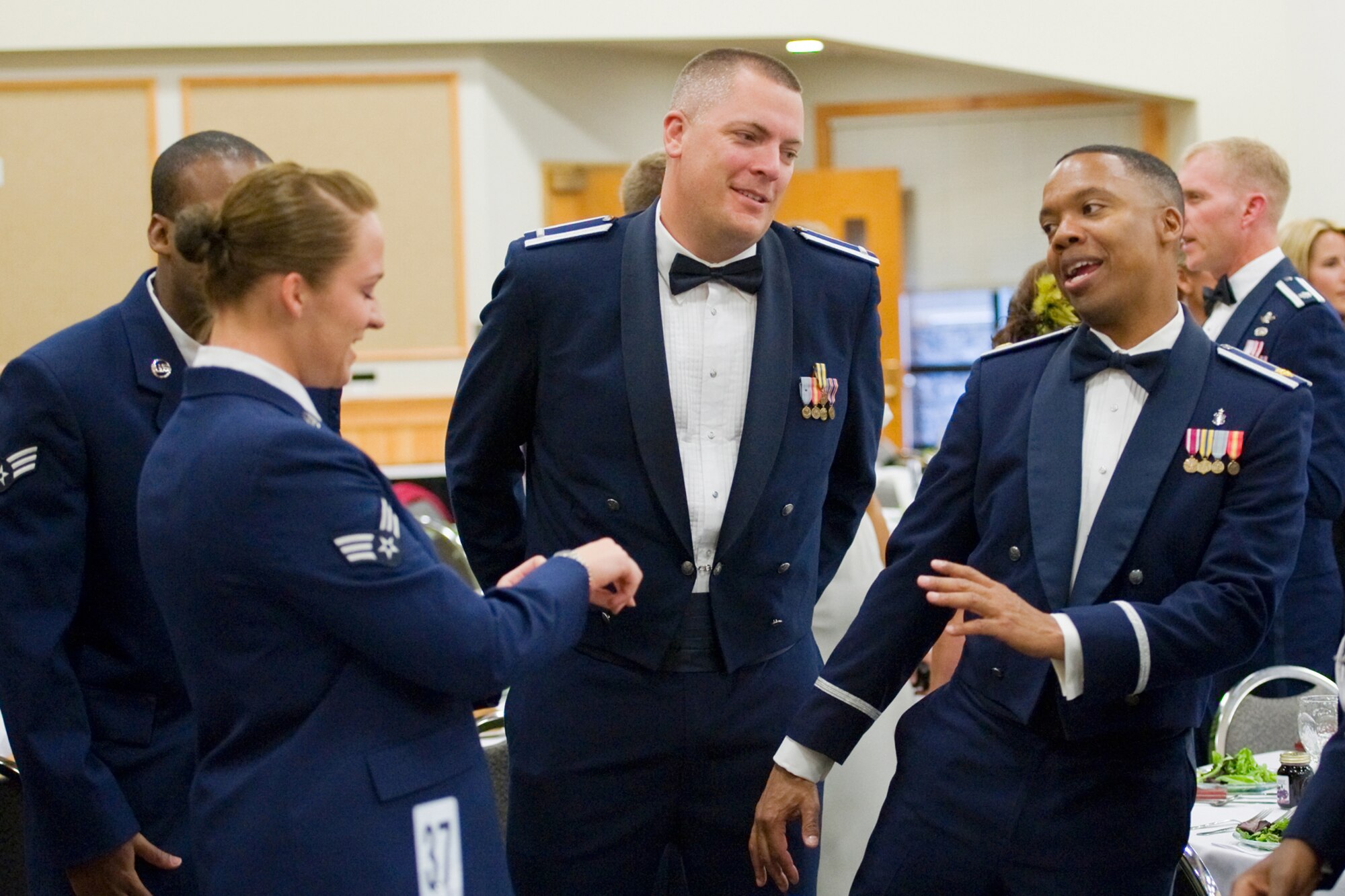 1st Lt. Neil Boots, 341st Medical Group group practice manager (center), chats with Senior Airman Victoria Baldwin, 341st Medical Support Squadron health service management apprentice, and Maj. Hector Stephenson, 341st MDG personal reliability program provider, during the social hour at the Air Force Ball.  (U.S. Air Force photo/Beau Wade)