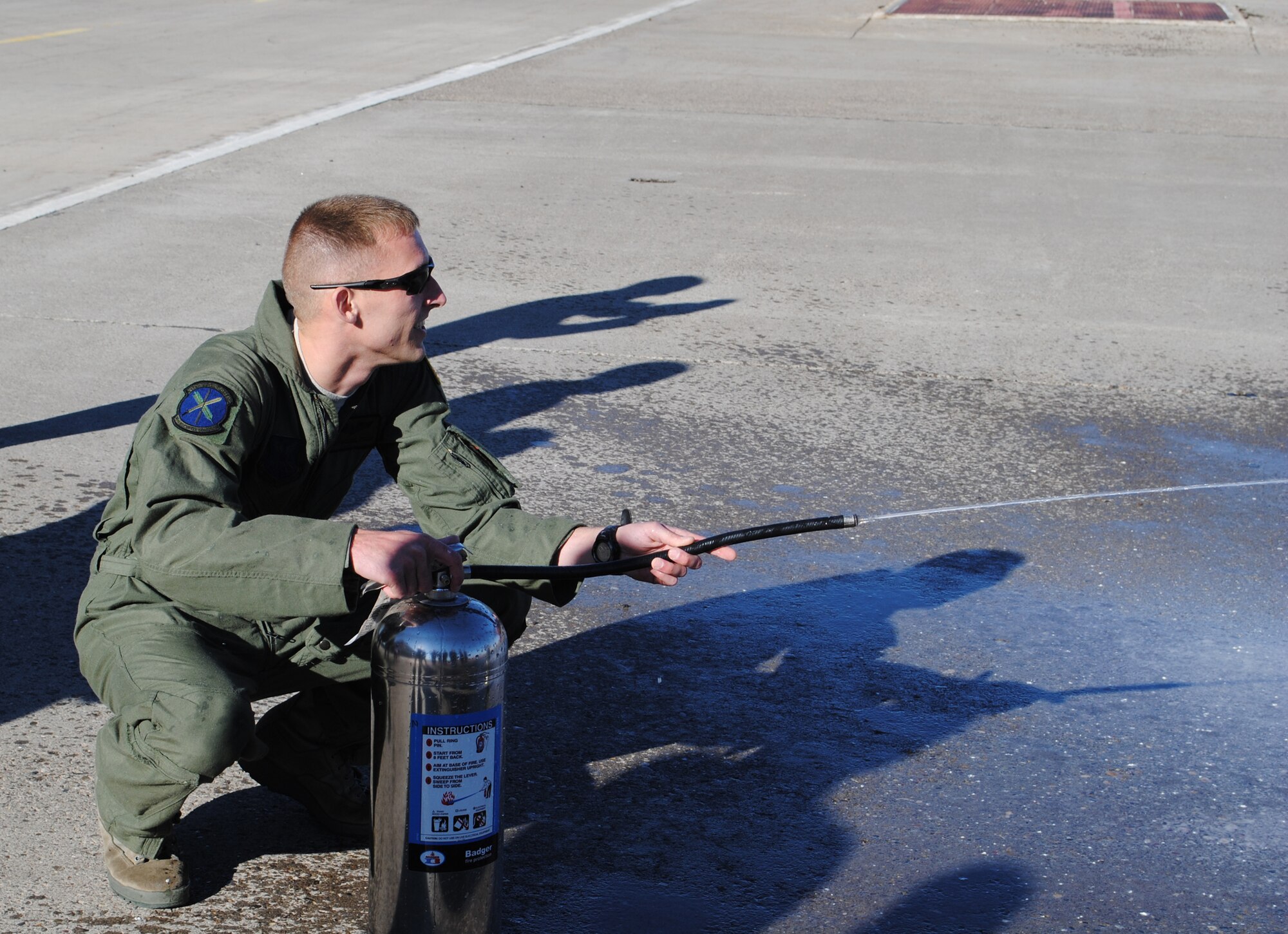 As part of an ongoing tradition, Frank uses a tank of water to spray a member of the 40th HS who returned from his final flight on a UH-1N Huey at Malmstrom.  (U.S. Air Force photo/Airman Cortney Paxton)