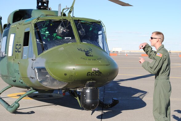 Staff Sgt. Michael Frank, 40th Helicopter Squadron flight engineer, motions to a crew that recently landed.  (U.S. Air Force photo/Airman Cortney Paxton)
