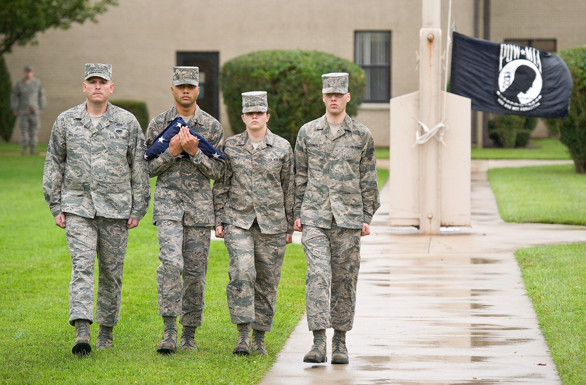 The folded American flag is carried by Team Dover members as the Prisoner of War/Missing in Action flag is flown at half staff during a retreat ceremony Sept. 23, 2011, at Dover Air Force Base, Del. Team Dover hosted a run and a vigil to commemorate American POWs and MIAs. (U.S. Air Force photo by Roland Balik)

