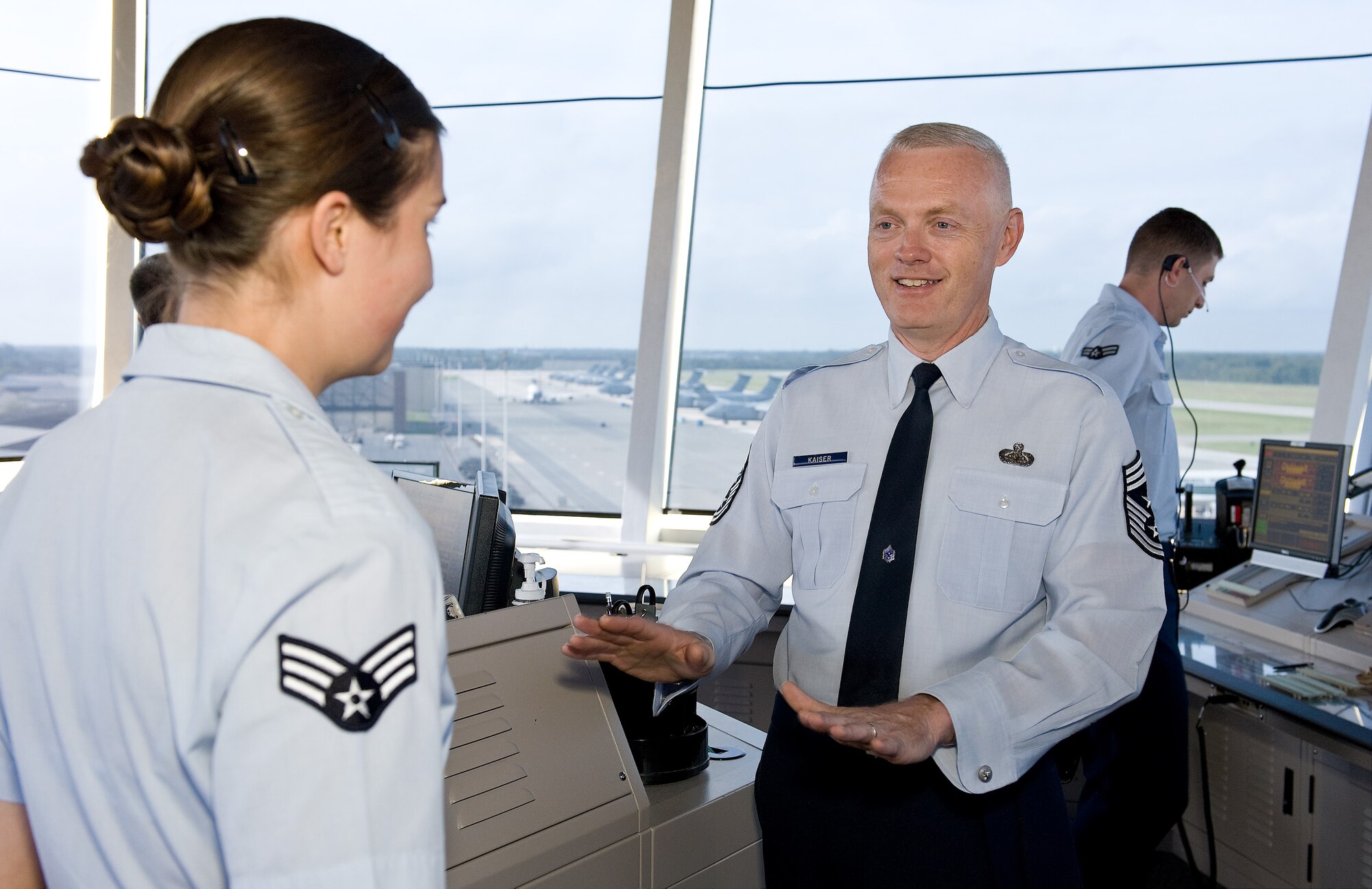 Chief Master Sgt. Richard Kaiser (middle), the command chief master sergeant of Air Mobility Command, speaks with Senior Airman Jessica Gregor, an air traffic controller with the 436th Operations Support Squadron, Sept. 26, 2011, at Dover Air Force Base, Del. Gregor was one of many Airmen who briefed Kaiser during his tour of Dover AFB. (U.S. Air Force photo by Roland Balik)