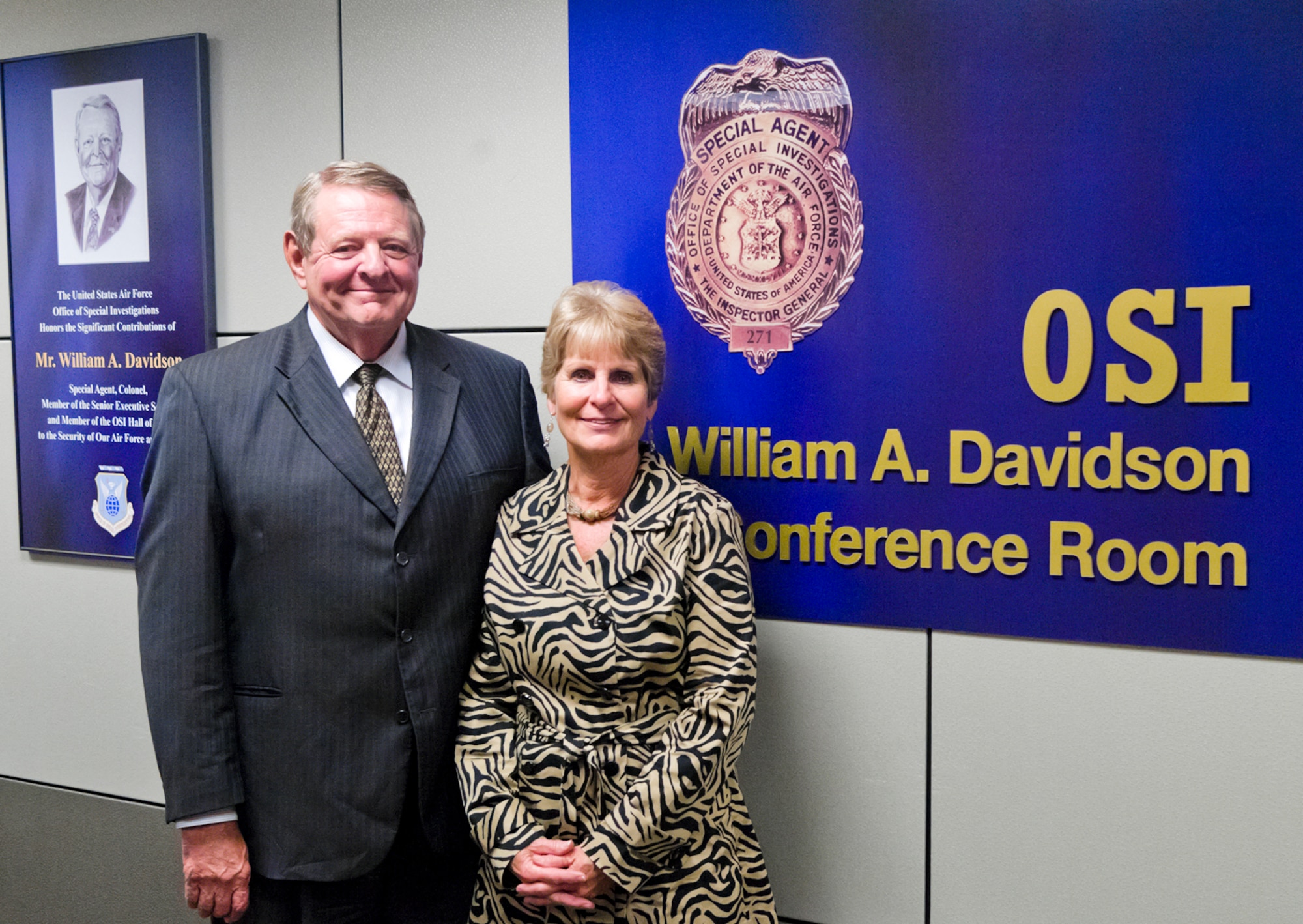 Administrative Assistant to the Secretary of the Air Force, Mr. William A. Davidson, and his wife, Peg, stand together in the newly-named William A. Davidson Conference Room. A display featuring Mr. Davidson's Air Force career can be seen on the wall behind them. Mr. Davidson and his wife were invited to the Air Force Office of Special Investigations Headquarters at Marine Corps Base Quantico, Va., Sept. 23 for a special tour of the facility. (U.S. Air Force Photo by Mr. Mike Hastings.)