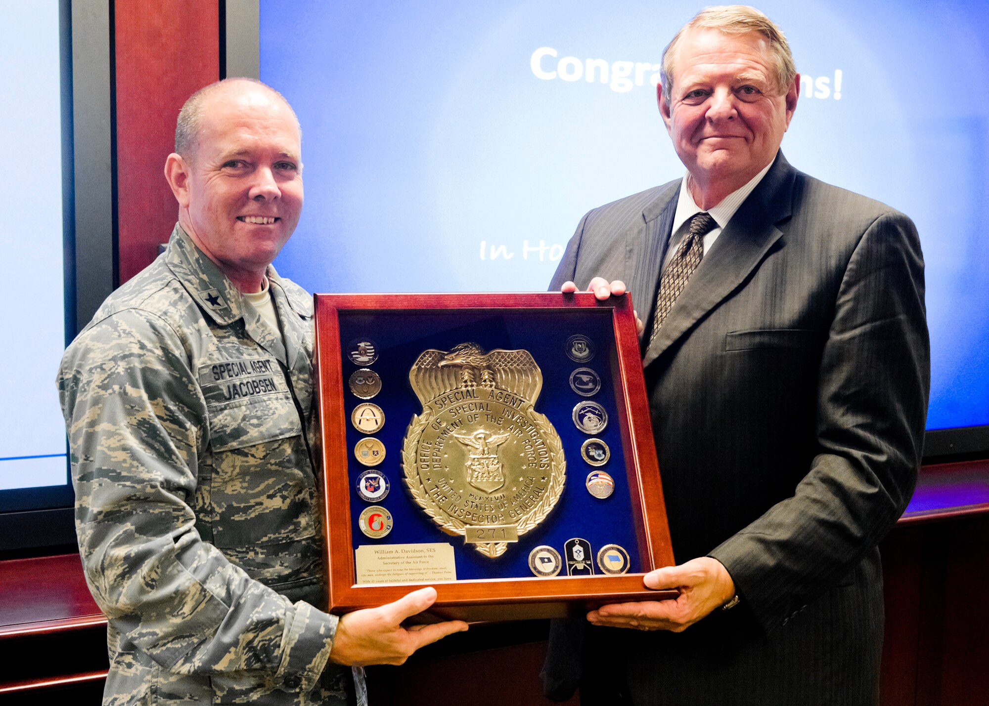 Administrative Assistant to the Secretary of the Air Force, Mr. William A. Davidson accepts a shadow box from Brig. Gen. Kevin Jacobsen, AFOSI commander. Mr. Davidson, a former OSI agent, received a special tour of the AFOSI Headquarters at Marine Corps Base Quantico, Va., Sept. 23. During his tour of the headquarters, OSI also announced the re-naming of the Investigations Collections Operations Nexus conference room to the William A. Davidson Conference Room. A special display featuring Mr. Davidson's Air Force career was unveiled for him and his wife, Peg, to mark the occasion. (U.S. Air Force Photo by Mr. Mike Hastings.)