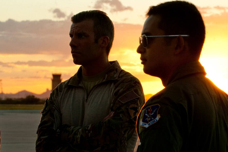 Master Sgt. Todd Popovic, pararescueman with the 48th Rescue Squadron, and 1st Lt. Willingham, a HC-130P Combat King pilot with the 79th Rescue Squadron, stand by as maintenance is performed on a HC-130P prior to a night operational training mission at Davis-Monthan Air Force Base, Az. on Sept. 23, 2011. The 79th RQS and 48th RQS routinely train together to provide realistic training scenarios for their personnel. (U.S. Air Force photo by Staff Sgt. Joshua J. Garcia/Released)
