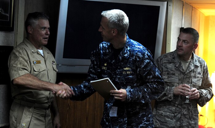 U.S. Navy Captain Logan Jones (center) greets Navy Cmdr. Charles Phillip aboard the Guided-Missile Cruiser USS Vicksburg (CG 69) after arriving pier-side, downtown Charleston, S.C, Sept. 23.  The Vicksburg moored at the Columbus street terminal at the port of Charleston from Sept. 23 unitil Sept. 26. Jones is the commanding officer of the USS Vicksburg and Phillip is the Joint Base Charleston 628th Mission Support Group deputy commander.  (U.S. Air Force photo/ Staff Sgt. Nicole Mickle)  
