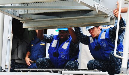 Sailors prepare to put the brow into place after the Guided-Missile Cruiser USS Vicksburg (CG 69) arrived  pier-side, downtown Charleston, S.C, Sept. 23. The USS Vicksburg moored at the Columbus street terminal at the port of Charleston from Sept. 23 unitil Sept. 26.  Leadership from Joint Base Charleston gathered at the terminal to greet the crew. Over the weekend students from The Citadel toured the USS Vicksburg.  Also, the Morale, Welfare, and Recreation LIBERTY program took Sailors to visit different local attractions in Charleston including the Aquarium.  (U.S. Air Force photo/ Staff Sgt. Nicole Mickle)
