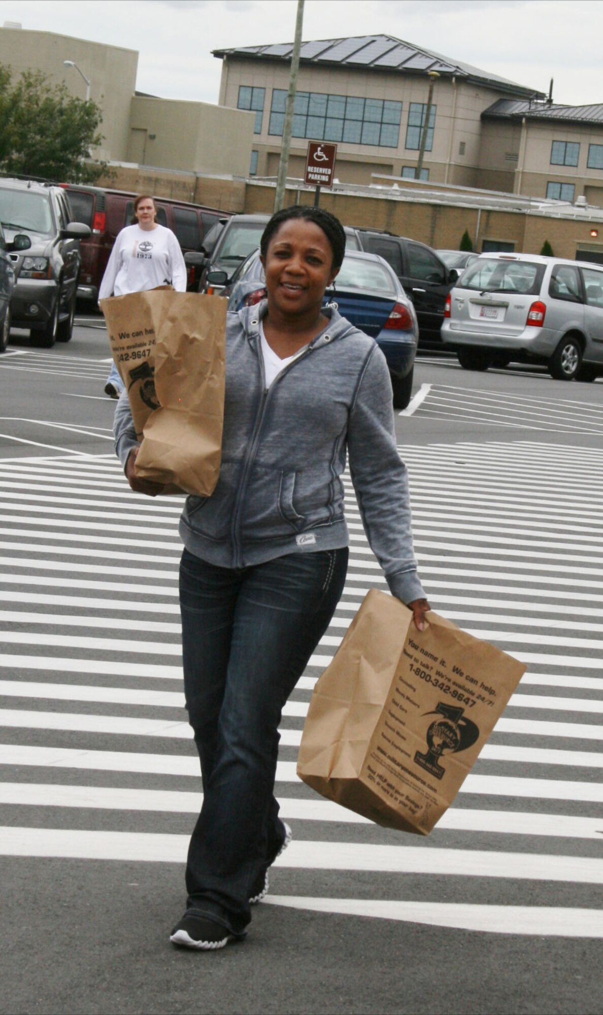 Tech. Sgt. Latersa Frazier, NCO in charge, Families of the Fallen Support Branch, Air Force Mortuary Affairs Operations, carries donations from commissary shoppers during a food drive for the Campus of the Families of the Fallen at Dover Air Force Base, Del., Sept. 19, 2011. (Courtesy photo)