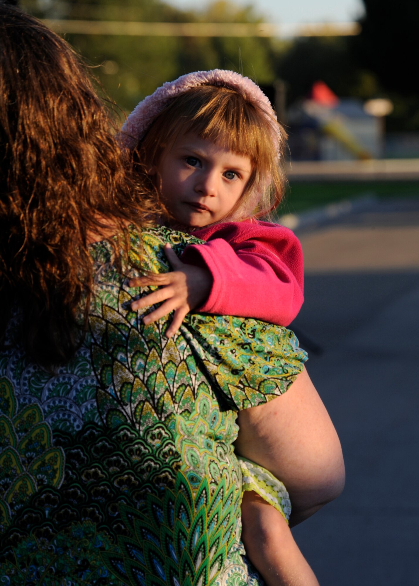 Bella Sorenson clings to her mother, Amy Sorenson, while her father is presented the prize for best fan photo at Mountain Home Air Force Base Wingman Day kick off Sept 23. Craig Sorenson was presented with both an autographed poster of the U.S. Air Force Thunderbirds and 366th Fighter Wing commander’s coin for his photo of his daughter enjoying Gunfighter Skies 2011. (U.S. Air Force photo by Senior Airman Angelina Drake)