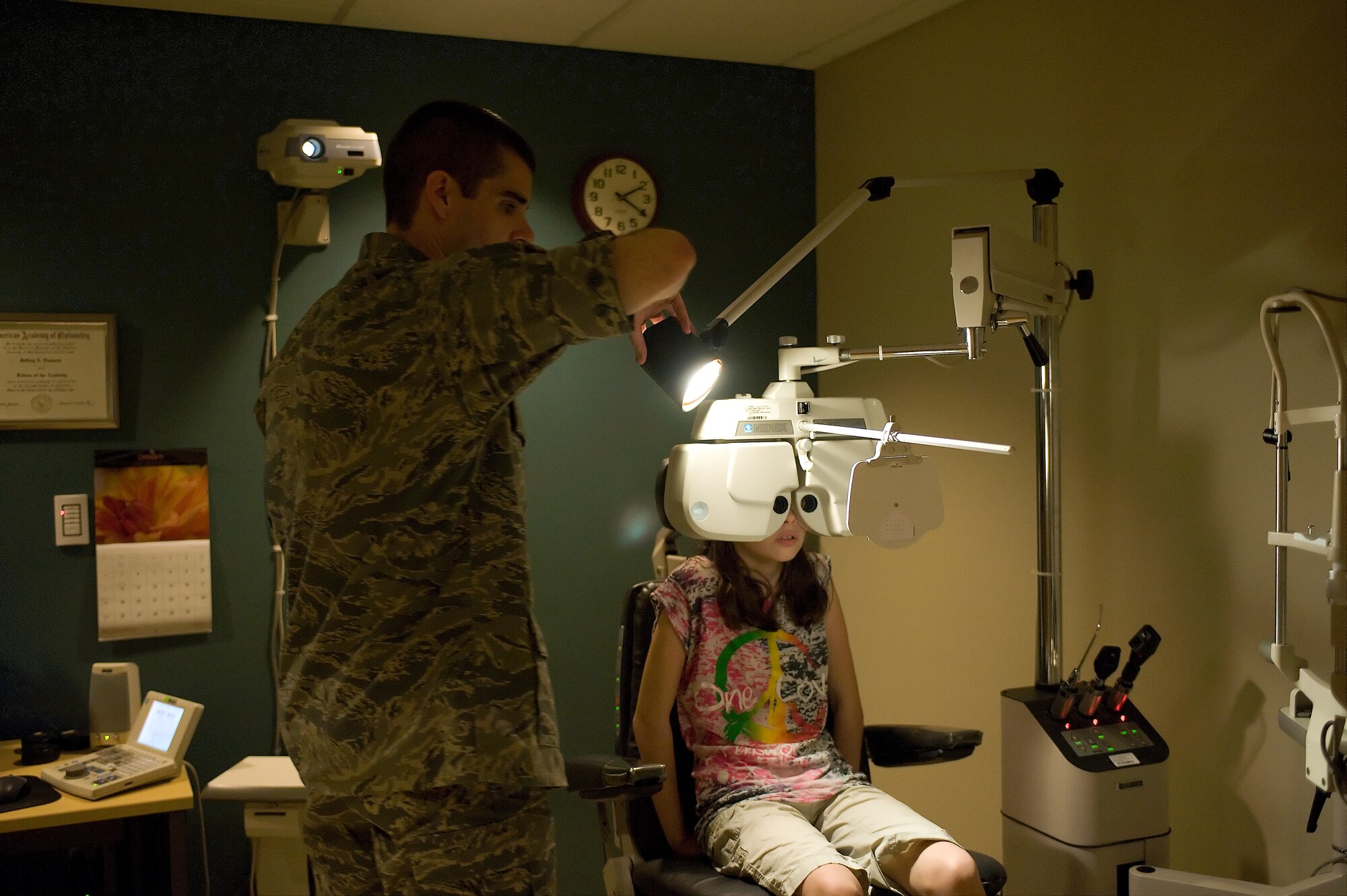 Maj. (Dr.) Jeffrey Newsom, the optometry flight commander for the 436th Aerospace Medicine Squadron, adjusts a light for Emma Lusignan Sept. 26, 2011, at Dover Air Force Base, Del. The Dover AFB Optometry Clinic is ranked number one in Air Mobility Command and number two in the Air Force. (U.S. Air Force photo by Steve Kotecki)