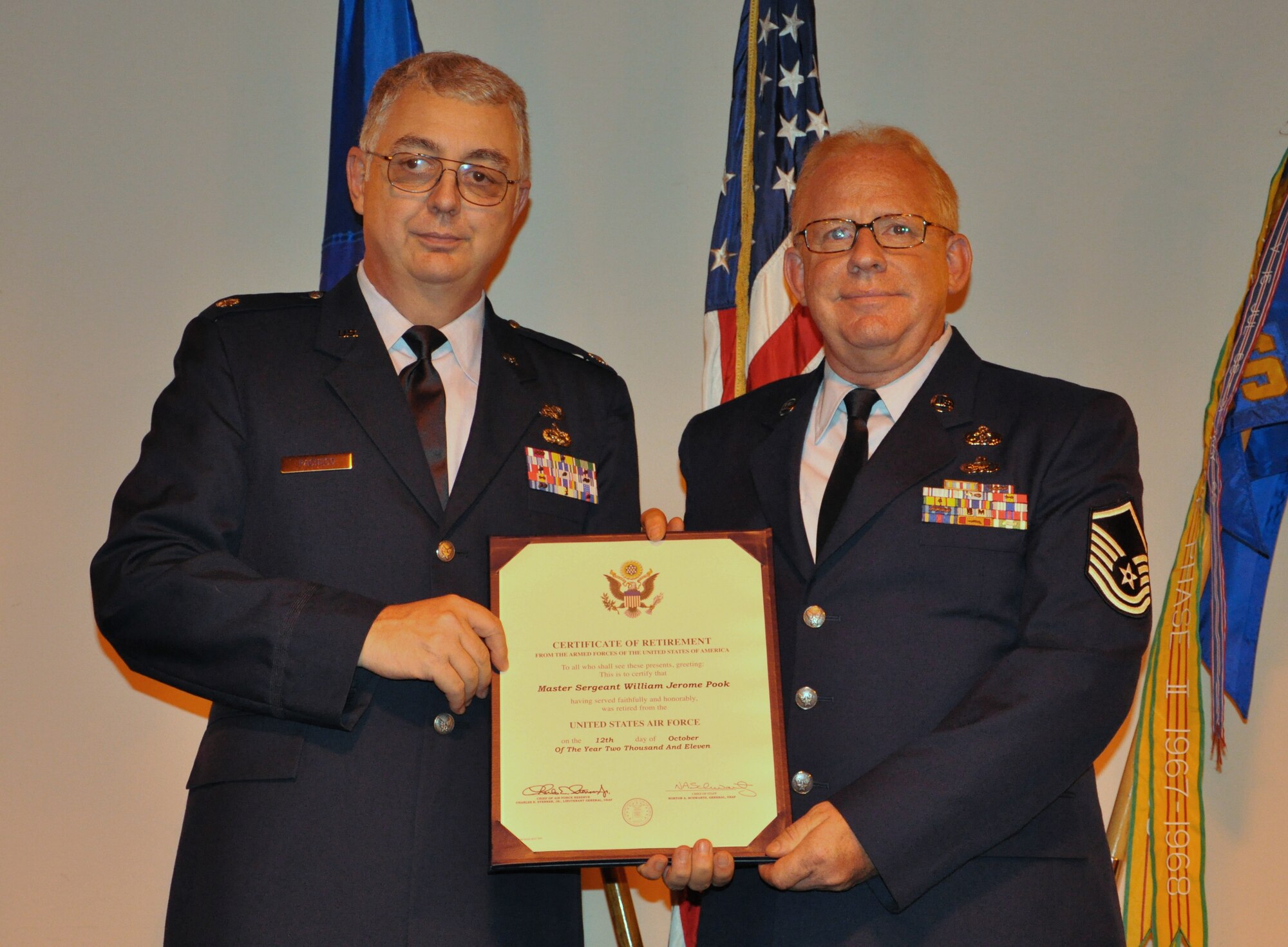 Retired Lt. Col. Daniel Pacheco (left) presents Master Sgt. William Pook, a reservist assigned to the 633rd Civil Engineer Squadron, with his certificate of retirement in a ceremony at the squadron’s Emergency Management flight warehouse at Langley Air Force Base, Va., Sept. 23, 2011. Pacheco, who officiated the retirement ceremony, met Pook in basic military training in 1971, and has never lost touch with him. (U.S. Air Force photo by Senior Airman Jason J. Brown/Released)