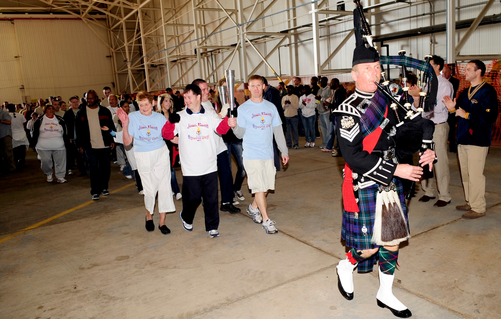 RAF MILDENHALL, England – Family members of the late Joan Mann, lead the traditional torch relay parade of champions before the start of games of the Joan Mann Special Sports Day here Sept. 24, 2011. Joan Mann’s family was just a few of the many distinguished guests who attended the event held to help bring the base and community closer together. (U.S. Air Force photo/Senior Airman Ethan Morgan)