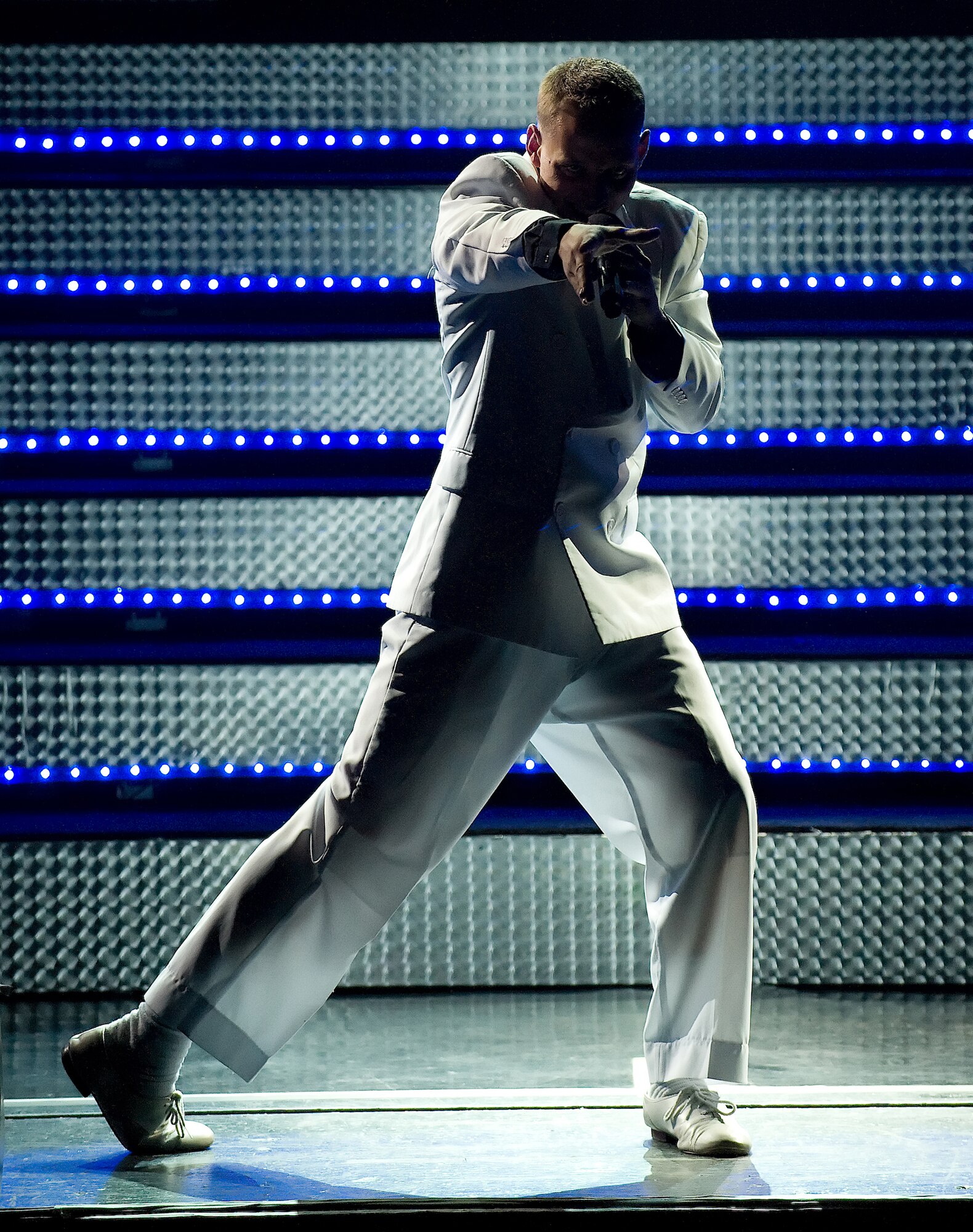 Airman 1st Class David Butler, Tops in Blue vocalist, 'cuts loose' during a previous year show in Dover, Del. The 2011 tour, titled Rhythm Nation, celebrates 55 years of premier entertainment and brings American music ranging from the early 1900s to current hits, providing a glimpse of popular music’s evolution through new rhythms and technology. (U.S. Air Force photo/Jason Minto) 
