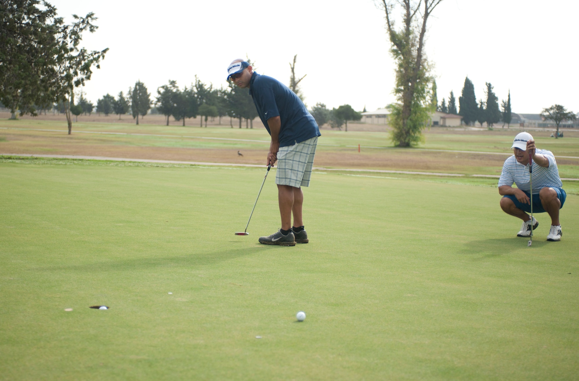 Chris Moed, 39th Communications Squadron, sinks a putt as Gustavo Miranda, 39th Security Forces Squadron, watches during the Club Championship Sept. 24, 2011, at the Hodja Lakes Golf Course, Incirlik Air Base, Turkey. Thirty-one people competed in the championship. Ryan Stebbins, 39th Force Support Squadron, won with a score of 154. (U.S. Air Force photo by Senior Airman Clayton Lenhardt/Released)