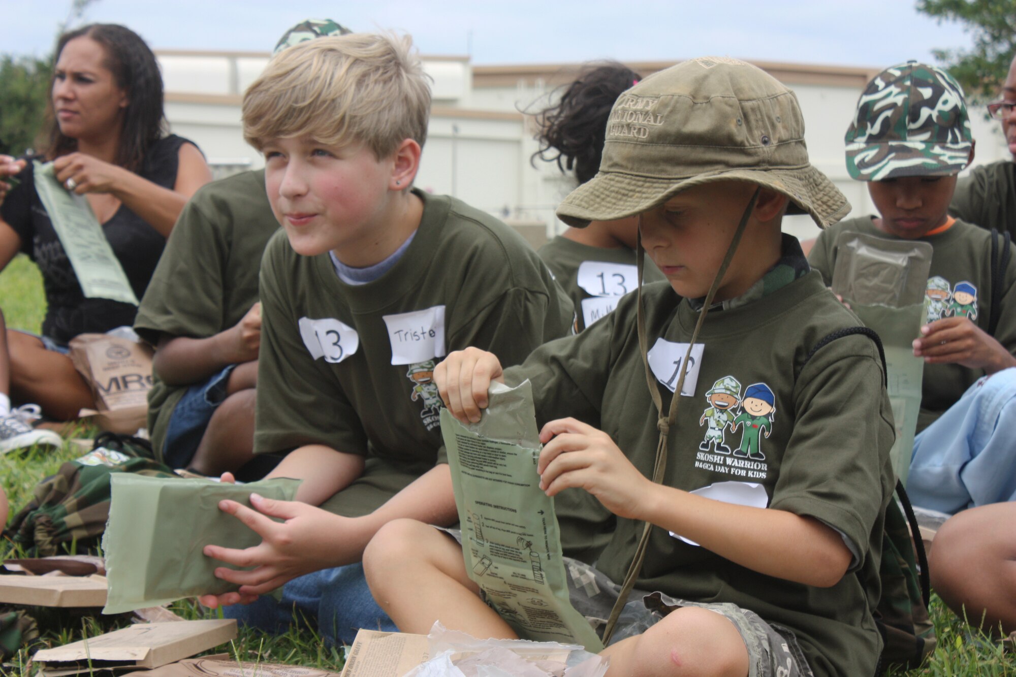Tristan Nesbitt and Zack Koivisto listen to their instructor as they try heating the main entrée in their MRE or meals ready to eat during Skoshi Warrior Sept. 24 at Kadena Air Base, Japan. For many of the warriors this was a new experience and even some of the adult volunteers needed assistance in heating up their meals. “More than 15 agencies and 75 volunteers from all branches of the services have come together to make this day a success for our military kids,” said Teresa Witschen, Kadena Youth Programs Chief. (U.S. Air Force photo/ Charles Gulick)