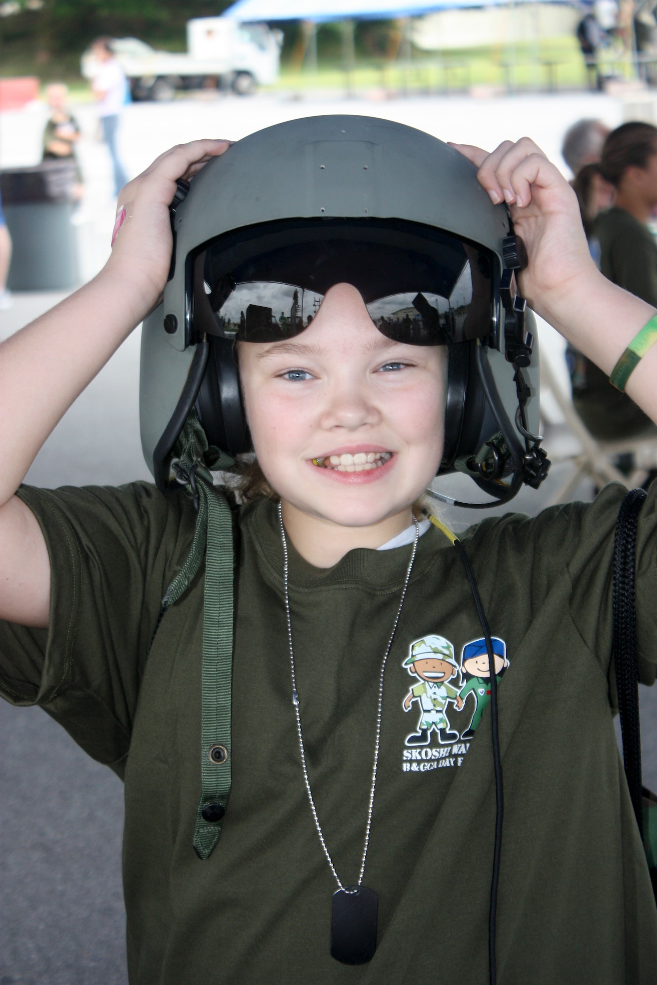 Jasmine Cooper tries on a flight helmet belonging to the 33rd Rescue Squadron at Kadena Skoshi Warrior Sept. 24 at Kadena Air Base, Japan. Each warrior was issued deployment gear including a T-shirt, backpack, hat and water bottle along with dog-tags, wallet and other items given throughout the day. (U.S. Air Force photos/ Charles Gulick)