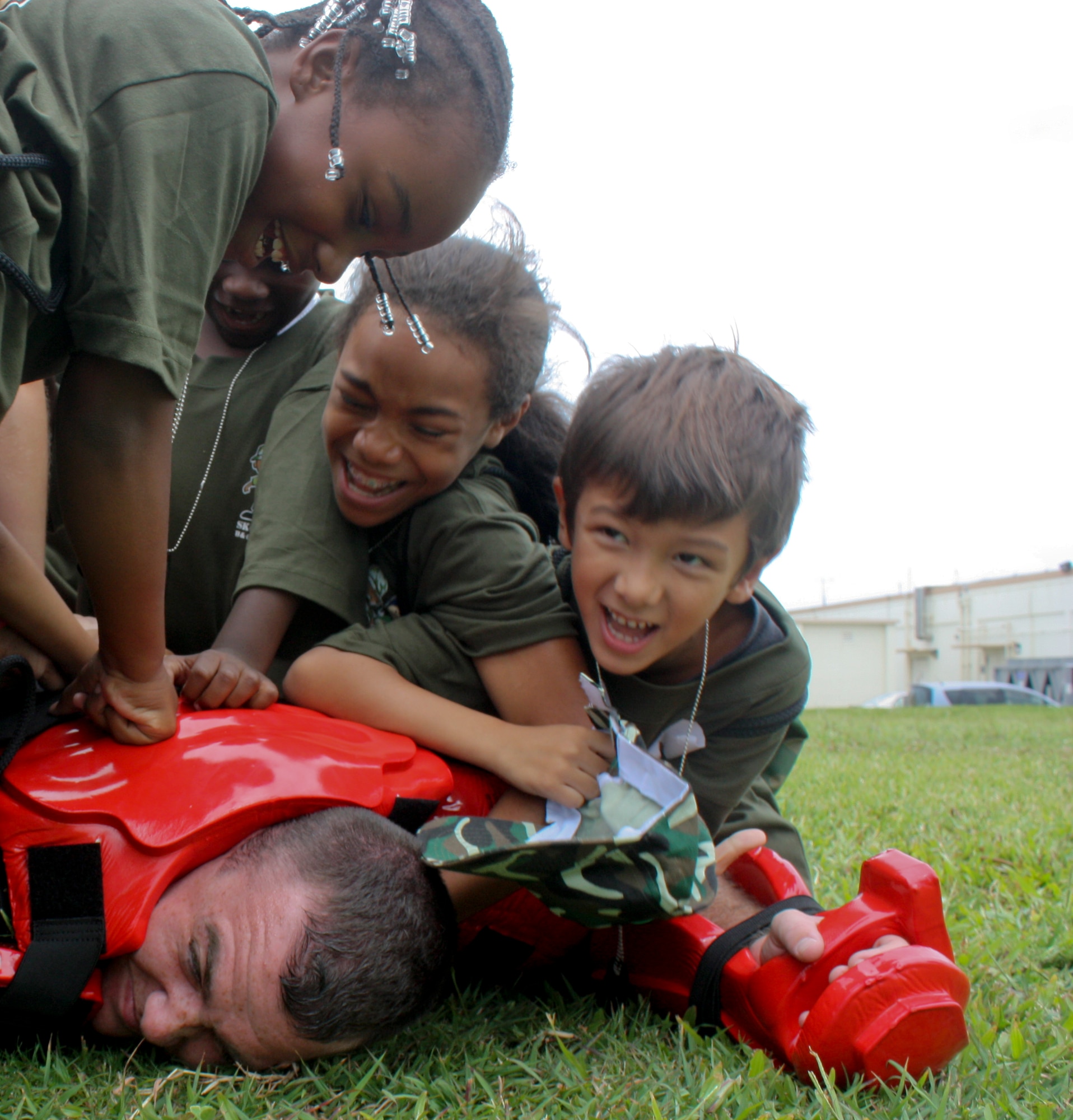 Airmen 1st Class Zachary Bungert, 18th Security Forces Squadron, gets attacked by participants of the Kadena Skoshi Warrior event Sept. 24 at Kadena Air Base, Japan. The event included a mock deployment line complete with finance, medical and other deployment briefings followed by many events including chemical suits, low-crawl, obstacle course, paint-ball target practice and military parade drills. (U.S. Air Force photos/ Charles Gulick)