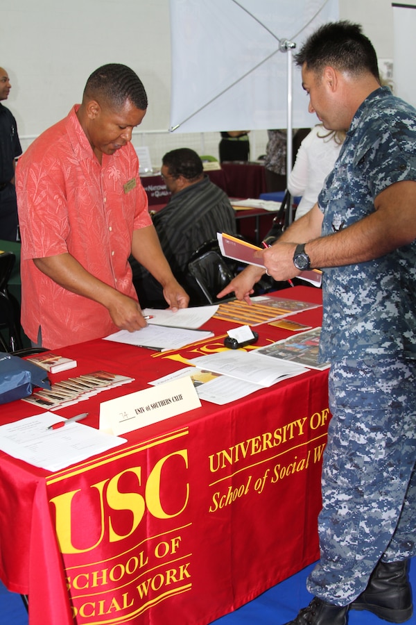 Petty Officer 1st Class Raphael Sanchez, hospital corpsman, Naval Medical Center San Diego, speaks to Isaac Ford Jr., University of Southern California representative, about opportunities available for service members at USC during the Marine Corps Community Services Career and Education Fair Sept. 27 at the Semper Fit Fieldhouse. MCCS Personal and Professional Development provided military members and their families access to information on credible employers, colleges, and universities. The fieldhouse was lined with 118 booths, 52 schools and 66 employers, with representitives standing by to talk to potential canidates. "USC supports the military because they bring a unique perspective to the field," said Ford.