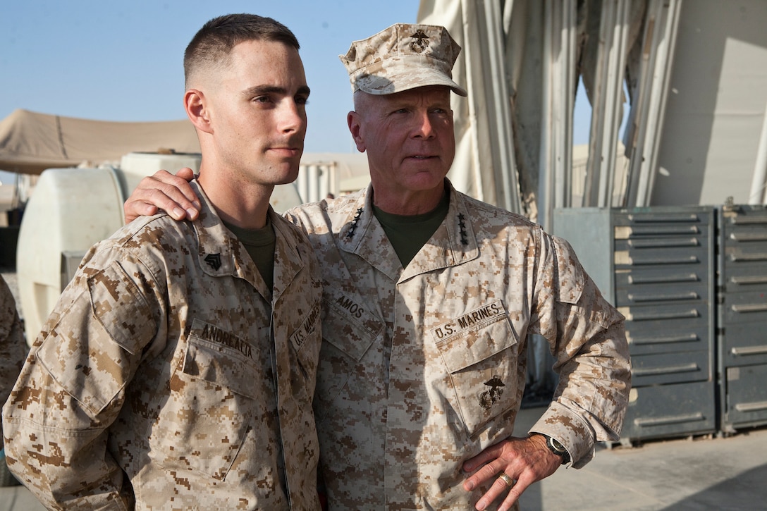Commandant of the Marine Corps Gen. James F. Amos, right, puts his arm around Sgt. Tyler J. Andreatta, an avionics and weapons technician with Marine Light Attack Helicopter Squadron 267, at Camp Bastion, Afghanistan Sept. 23. Andreatta was awarded the Purple Heart for injuries he sustained during combat.