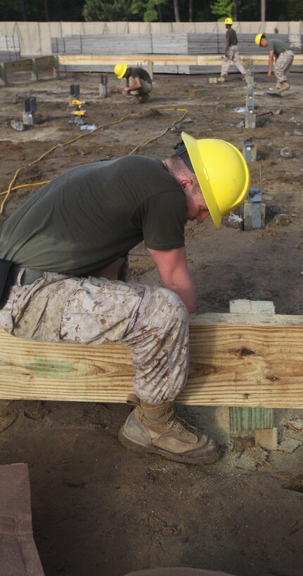 A combat engineer with Marine Wing Support Squadron 271, 2nd Marine Aircraft Wing from Marine Corps Air Station Cherry Point works on the frame of a hut for the reconstruction of a simulated forward operating base. The simulated forward operation base will be used to train Marines during stage two of School of Infantry-East’s Marine Combat Training.