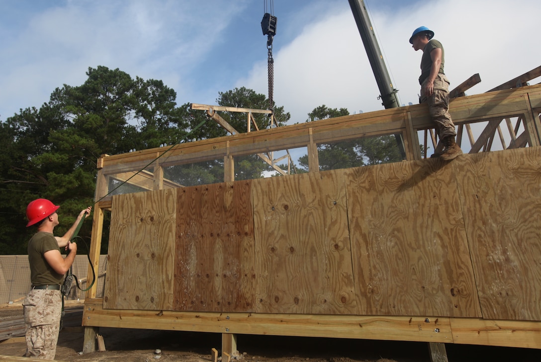 Marines with Marine Wing Support Squadron 271, 2nd Marine Aircraft Wing from Marine Corps Air Station Cherry Point build the roof of a hut. The hut will be a part of a simulated forward operating base built to train new Marines during stage two of School of Infantry – East’s Marine Combat Training.