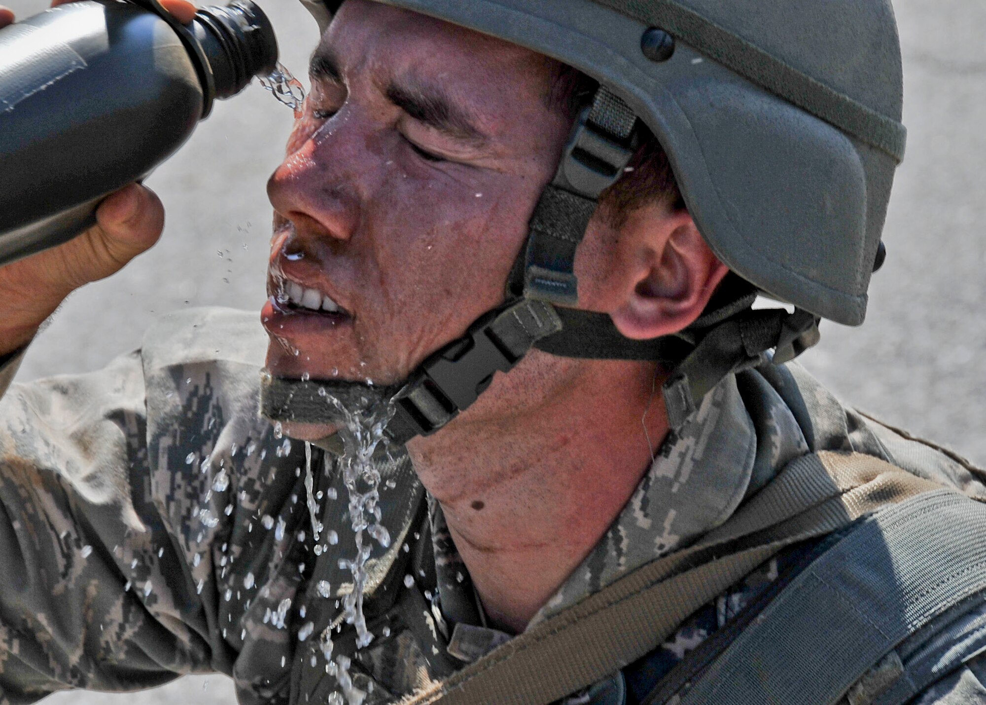 Staff Sgt. Stephen Hebblethwaite, 51st Security Forces Squadron member, pours water on his face after completing the confidence course Sept. 27, 2011.  The confidence course is an obstacle course that tests the participant’s abilities to survive as a team while communicating when placed in stressful situations. (U.S. Air Force photo/Senior Airman Adam Grant)     