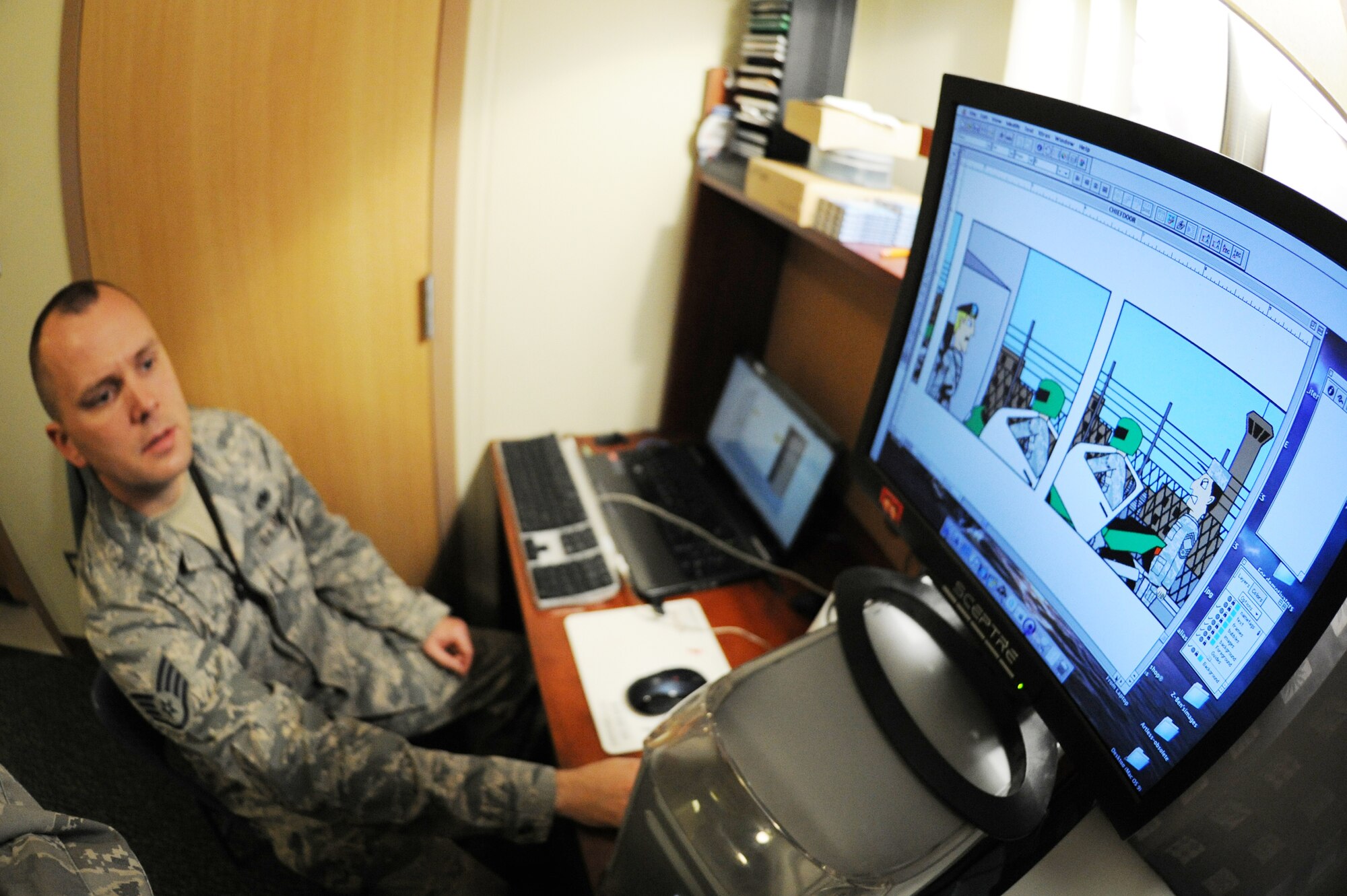 Staff Sgt. Benjamin Schneider, 8th Maintenance Squadron munitions storage crew chief, demonstrates how he puts together a comic strip at Kunsan Air Base, Republic of Korea, Sept. 28, 2011. Schneider has created 248 comic strips, 16 of which have been published in the Crimson Sky newspaper. (U.S. Air Force photo by Senior Airman Brittany Y. Bateman/Released)