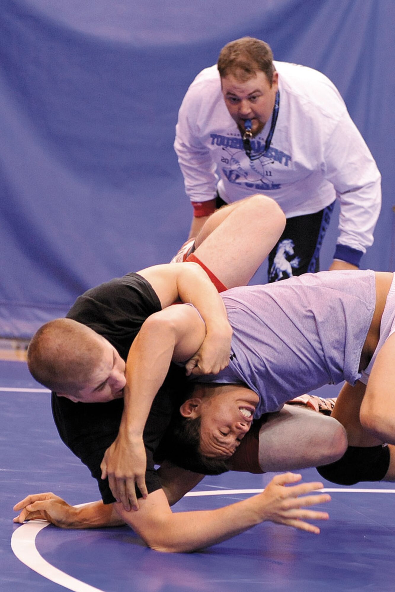 Ryan Hudson (black shirt) takes Nicholas Badis to the mat in the first match of the JBER wrestling meet. Hudson defeated Badis, a fellow paratrooper from D Company, 3rd Battalion (Airborne), 509th Infantry Regiment, twice to take top honors in the 167.5-187.5-pound weight class.   (U.S. Air Force photo/John Pennell)