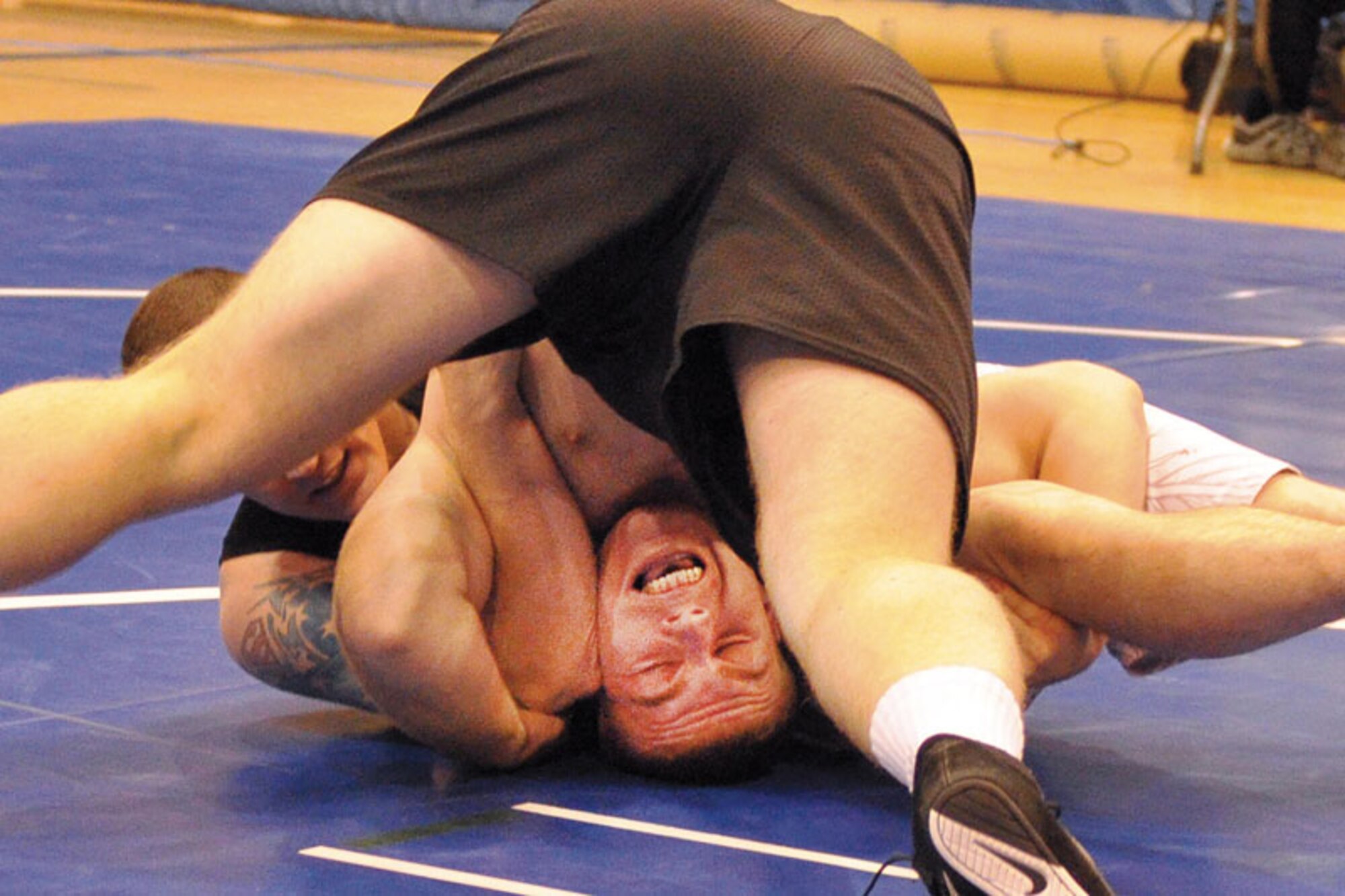 John Logan Jr. (bottom) grimaces as he tangles with Jason Moore in their Sept. 21 match as part of the Joint Base Elmendorf-Richardson wrestling meet at Buckner Physical Fitness Center. Logan, of F Company, 725th Brigade Support Battalion, defeated Moore, of the 95th Chemical Company, and won the 187.5-214-pound weight class.  (U.S. Air Force photo/John Pennell)