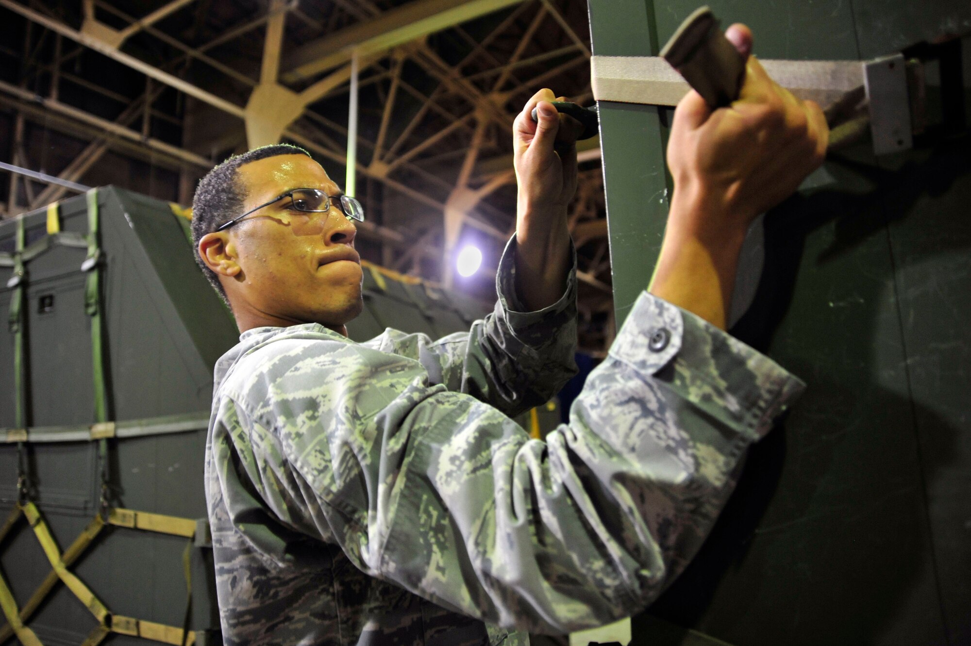 MISAWA AIR BASE, Japan – Airman Basic Kameron Dean, 35th Security Forces Squadron, tightens straps on cargo during an initial readiness response exercise here Sept. 28. The purpose of the exercise is to test the 35th Fighter Wing’s ability to generate aircraft and deploy combat power anywhere they are asked to deploy to. (U.S. Air force photo/ Staff Sgt. Nathan Lipscomb)