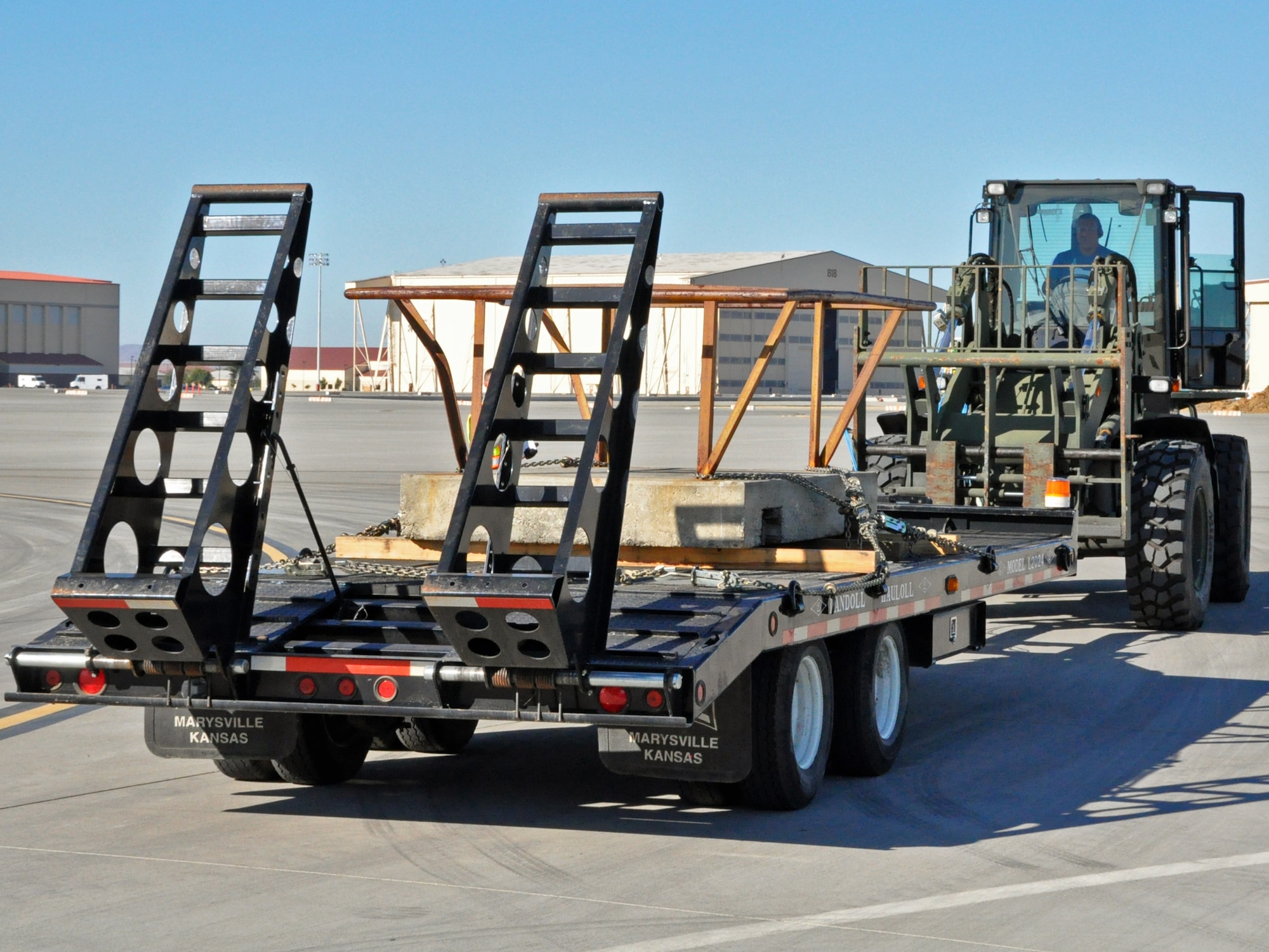 The driver of an all-terrain forklift prepares to push a trailer with extra weights on it Sep. 21 on the flightline at Travis. Travis aerial porters gradually added more weight to the trailer as they tested the attachment on the forklift that allows it to push and pull cargo. (Staff Sgt. Patrick Harrower)