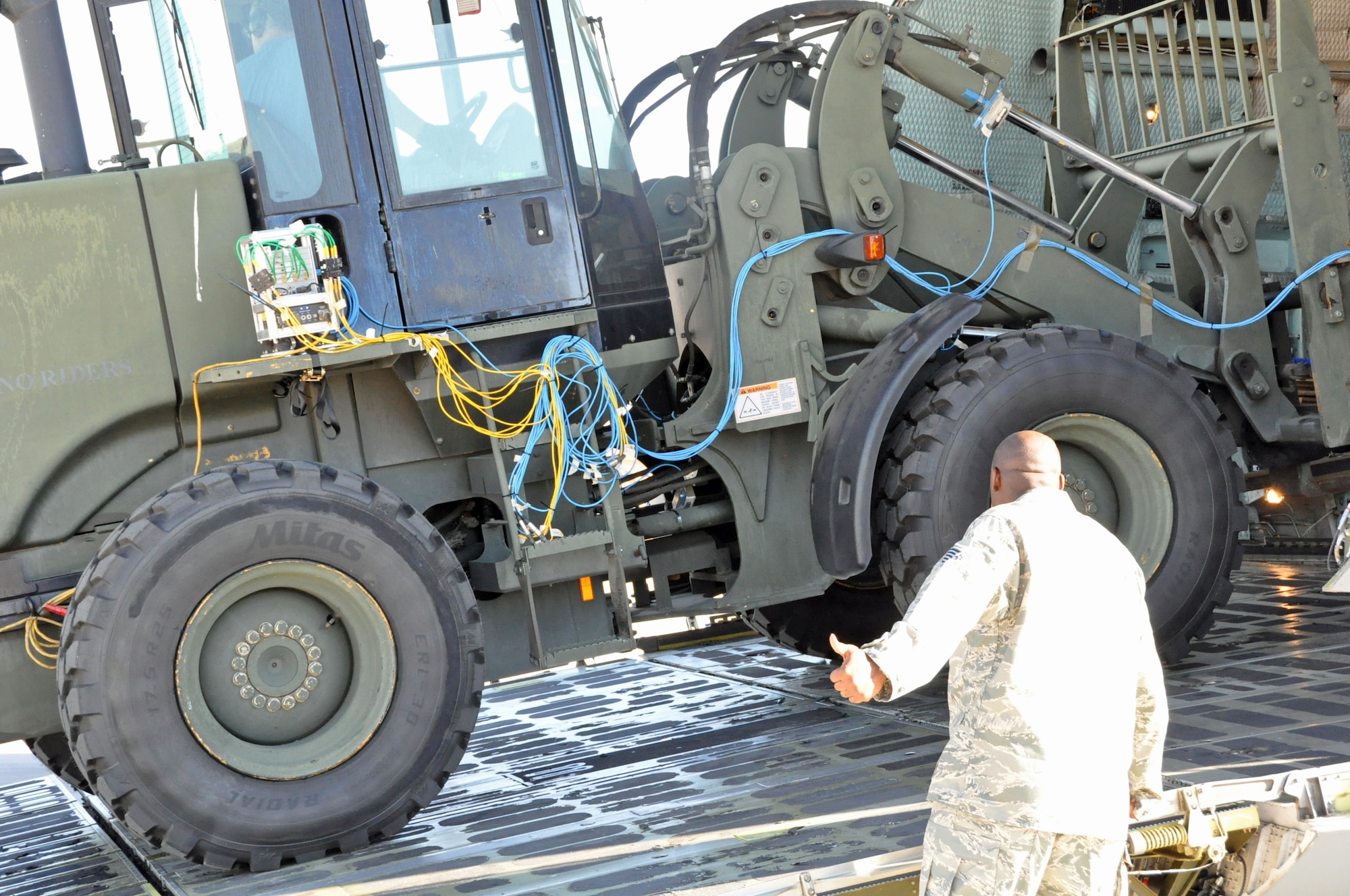 Tech. Sgt. Creighton King, Air Mobility Command Headquarters, gives a thumbs up to show a forklift driver he is clear as he backs down a C-5 Galaxy cargo ramp Sep. 21 on the flightline at Travis. (U.S. Air Force photo/ Staff Sgt. Harrower)