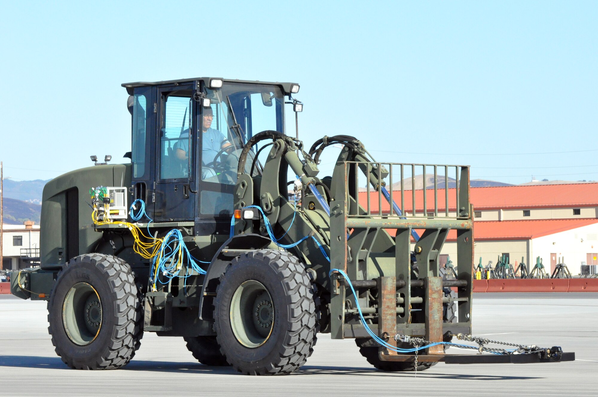 The driver of an all-terrain forklift waits to hook up to a trailer Sep. 21 on the flightline at Travis. The forklift is fitted with special test equipment to test the stress on the pintle hook attached to the forks on the front. (U.S. Air Force photo/ Staff Sgt. Patrick Harrower)