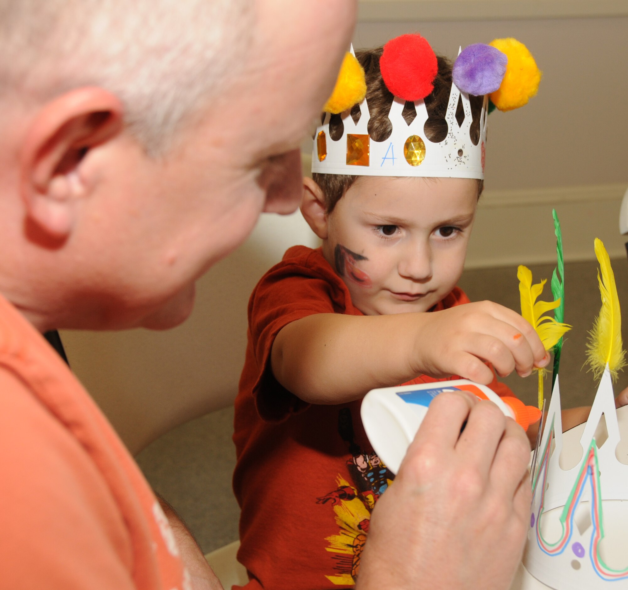 Capt. Dean Doré, 81st Inpatient Operations Squadron, helps his son Alexander, 3, glue feathers onto a crown he’s making for dad during an outreach program at Lynn Meadows Discovery Center Sept. 24.  The program was sponsored by the airman and family readiness center’s exceptional family member program and Child Find to
help families connect with available community and base resources.  Alexander’s mom is Tara Doré.  (U.S. Air Force photo by Kemberly Groue)