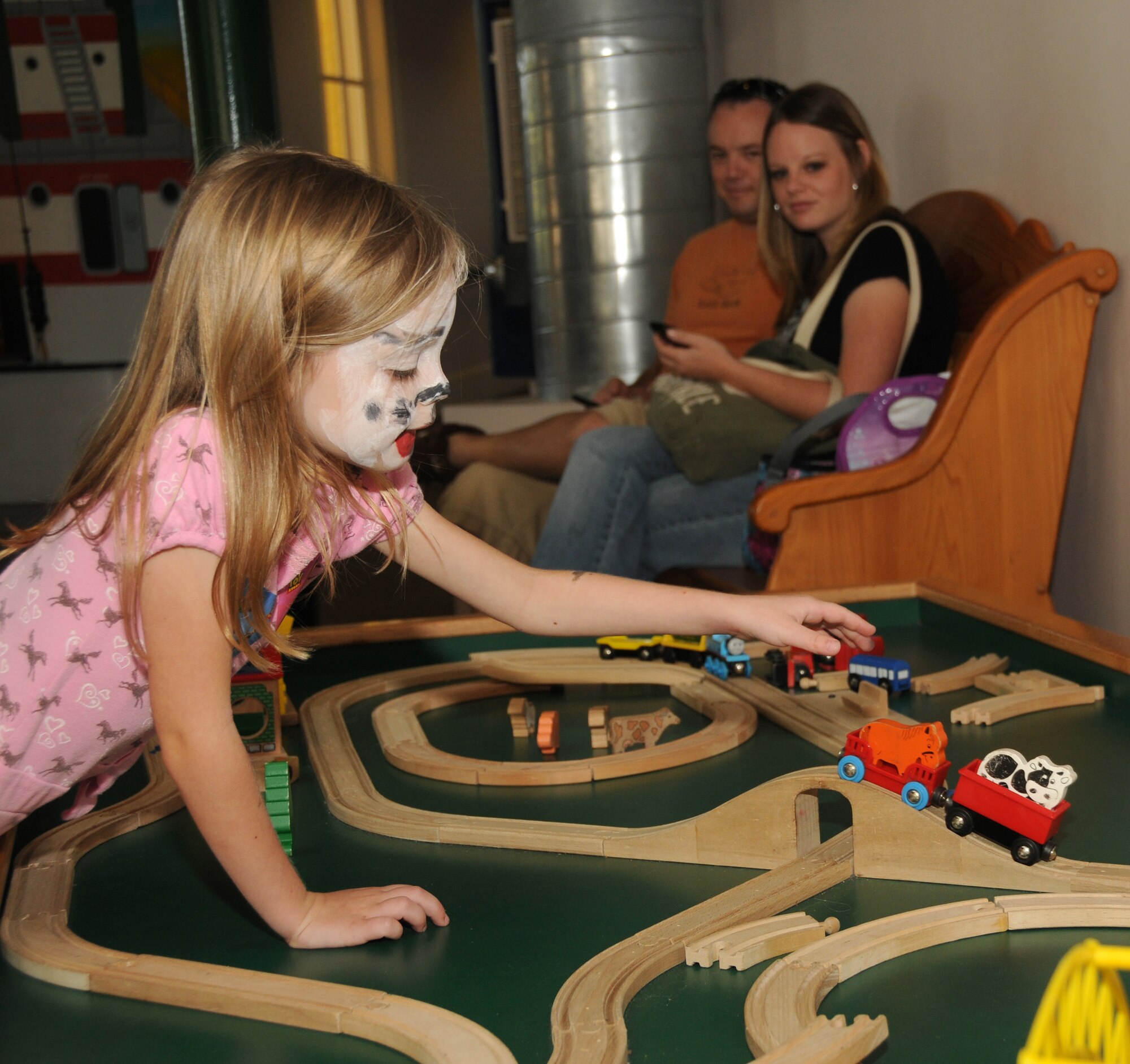 Aspen Middleton, 6, left, plays with a wooden toy train set as her parents, Tech. Sgt. Scott and Beth Middleton, 334th Training Squadron, look on Sept. 24. Saturday’s outreach program at Lynn Meadows Discovery Center was sponsored by the airman and family readiness center’s exceptional family member program and Child Find to
help families connect with available community and base resources.  (U.S. Air Force photo by Kemberly Groue)