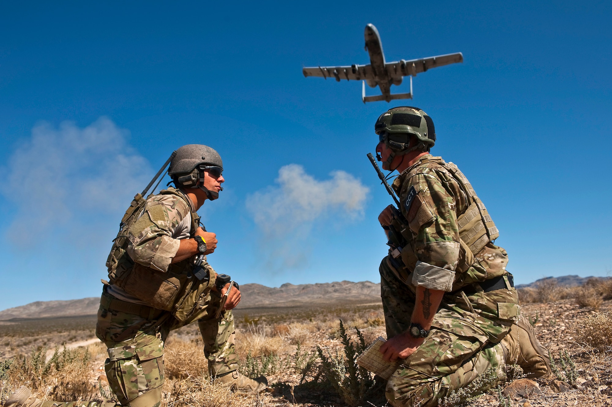 U.S. Air Force Senior Airman Corban Caliguire and Tech. Sgt. Aaron Switzer, 21st Special Tactics Squadron joint terminal attack controllers, from Pope Field, N.C., call for an A-10 Thunderbolt II to due a show of force during a close air support training mission Sept. 23, 2011, at the Nevada Test and Training Range.  Joint Terminal Attack Controllers perform proficiency training with U.S. Air Force Weapons School students during the close air support phases of the Weapons School six-month, graduate-level instructor course. (U.S. Air Force photo by Tech. Sgt. Michael R. Holzworth/Released)